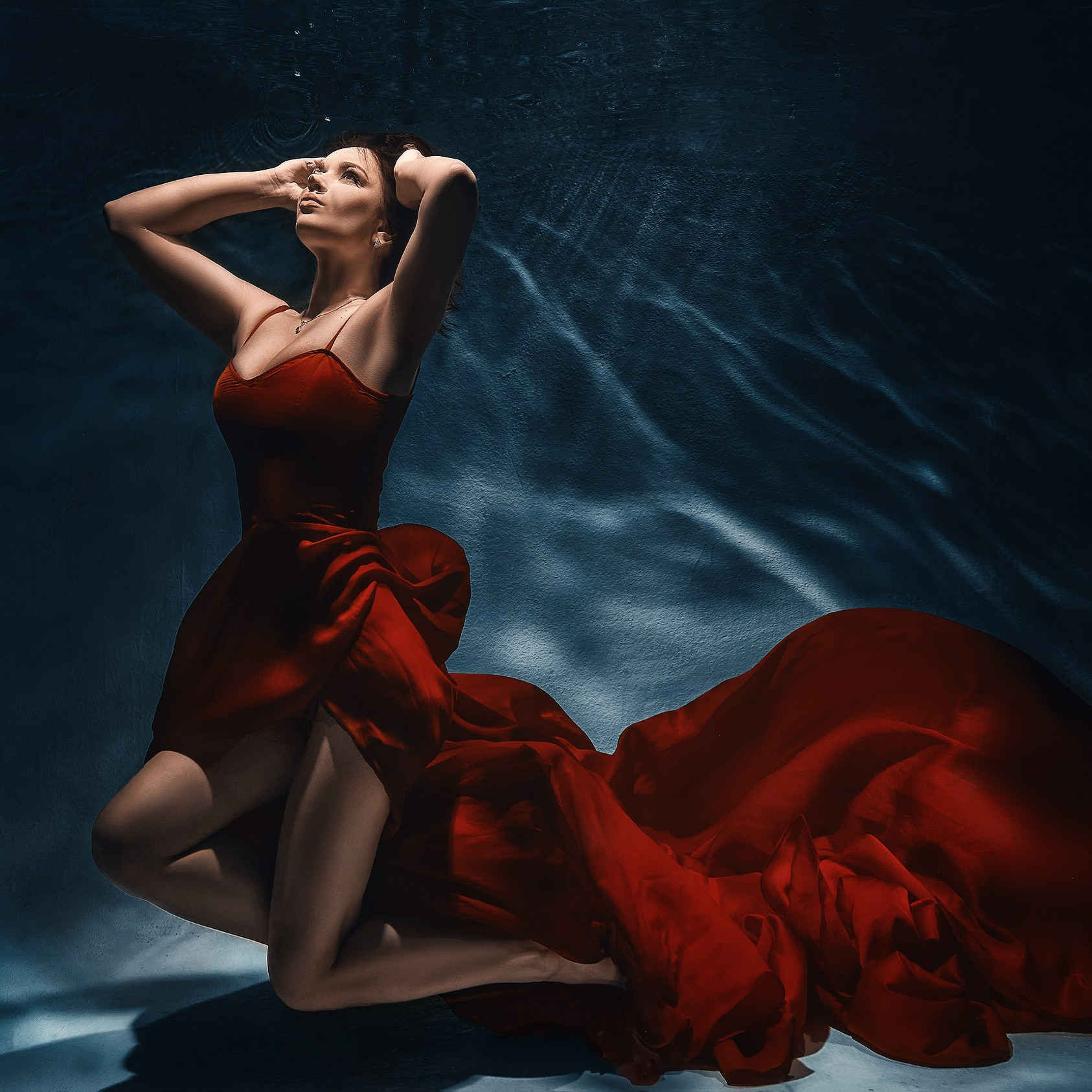 Подводная съемка в Казани, съемка модели под водой в красном платье, молодая девушка позирует под водой в красивом красном платье