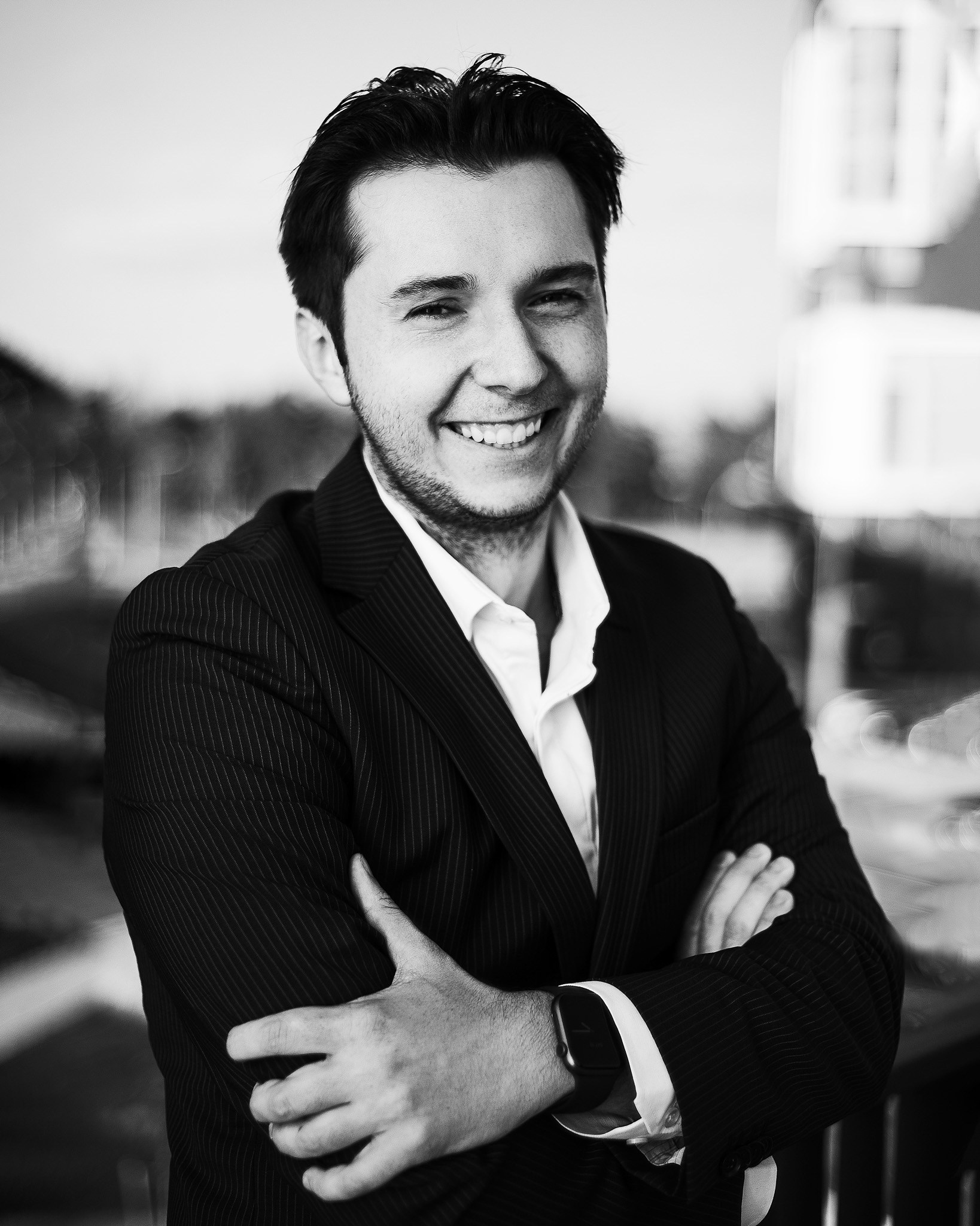 Фотограф Роман Романов — Бизнес-портрет. Черно-белый уличный портрет парня в пиджаке и улыбкой на лице.