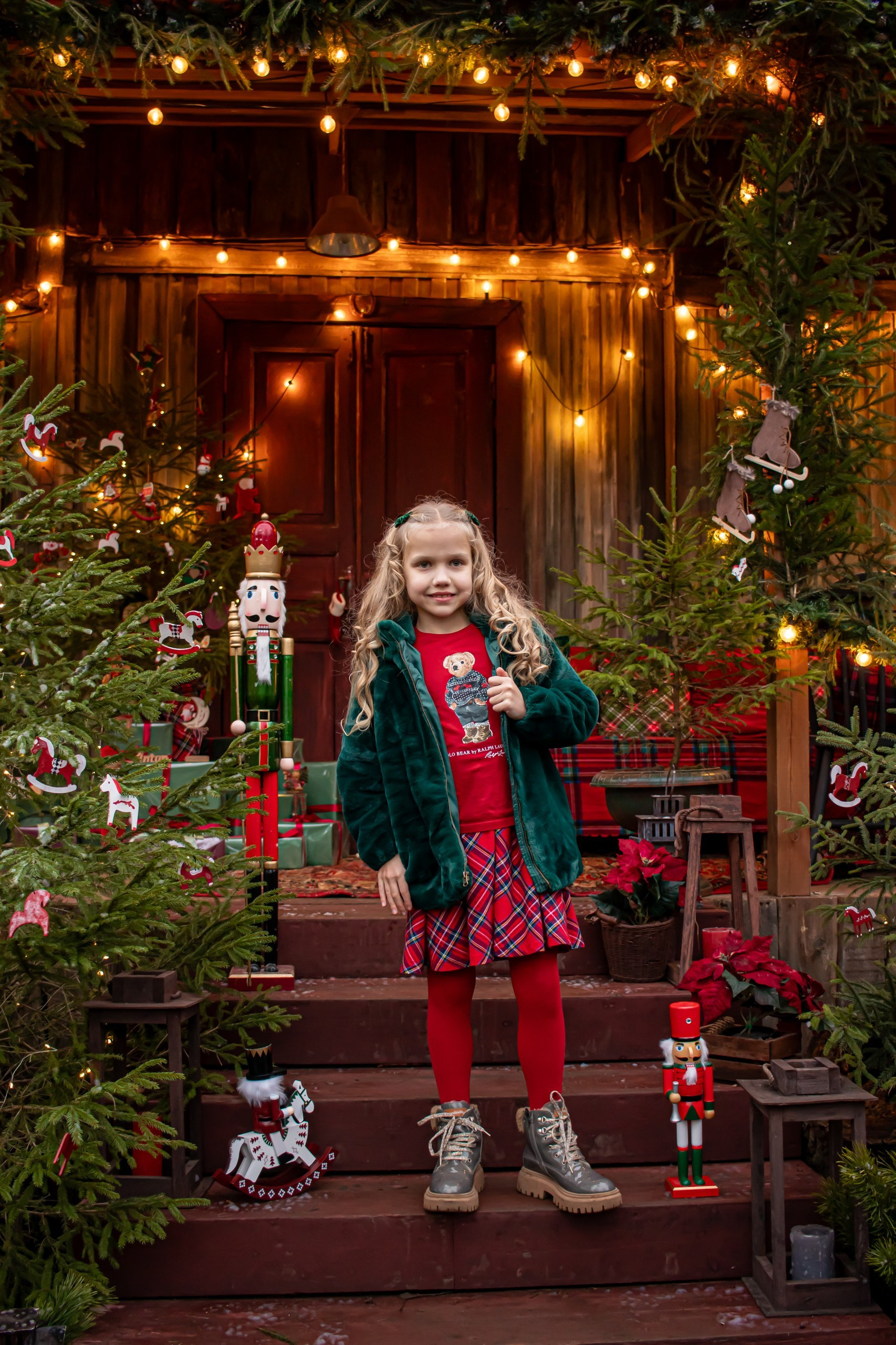 Новогодний портрет девочки в зелёной шубке и клетчатой юбке в шале, фотограф Карасёва Елена"