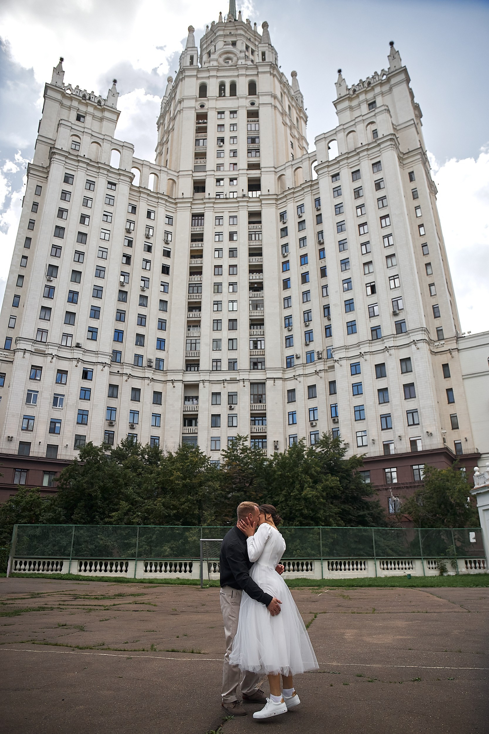 Жених и невеста обнимаются на фоне сталинской высотке на Котельнической набережной