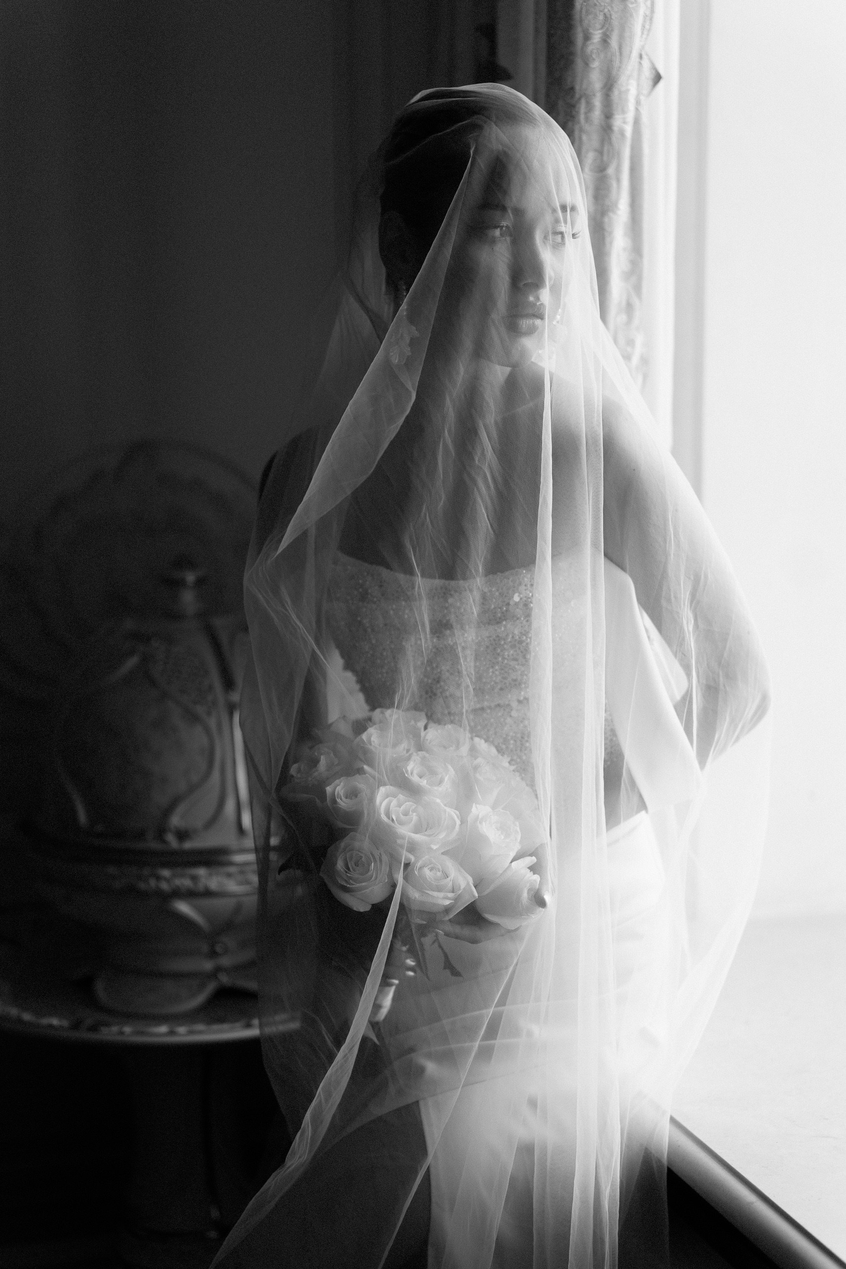 Чёрно-белая фотография невесты в фате у окна — камерная свадебная история в Trezzini Palace Hotel СПб