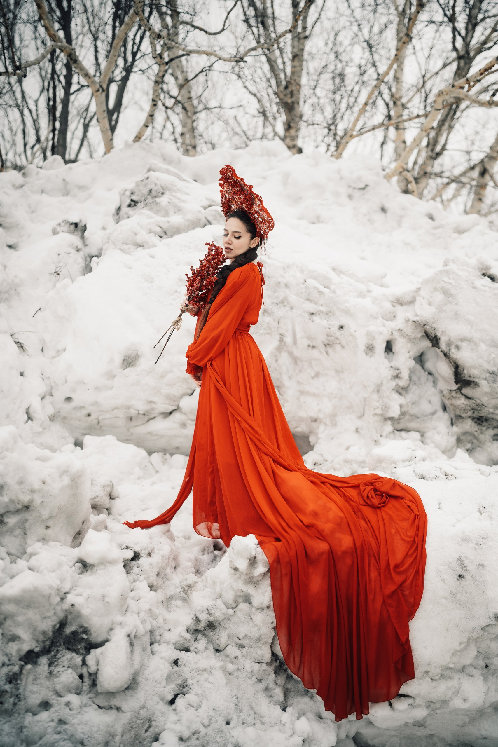 Художественная фотосессия девушки в красном платье среди тающего снега, контраст весны и городского пейзажа, портретная съёмка на улице