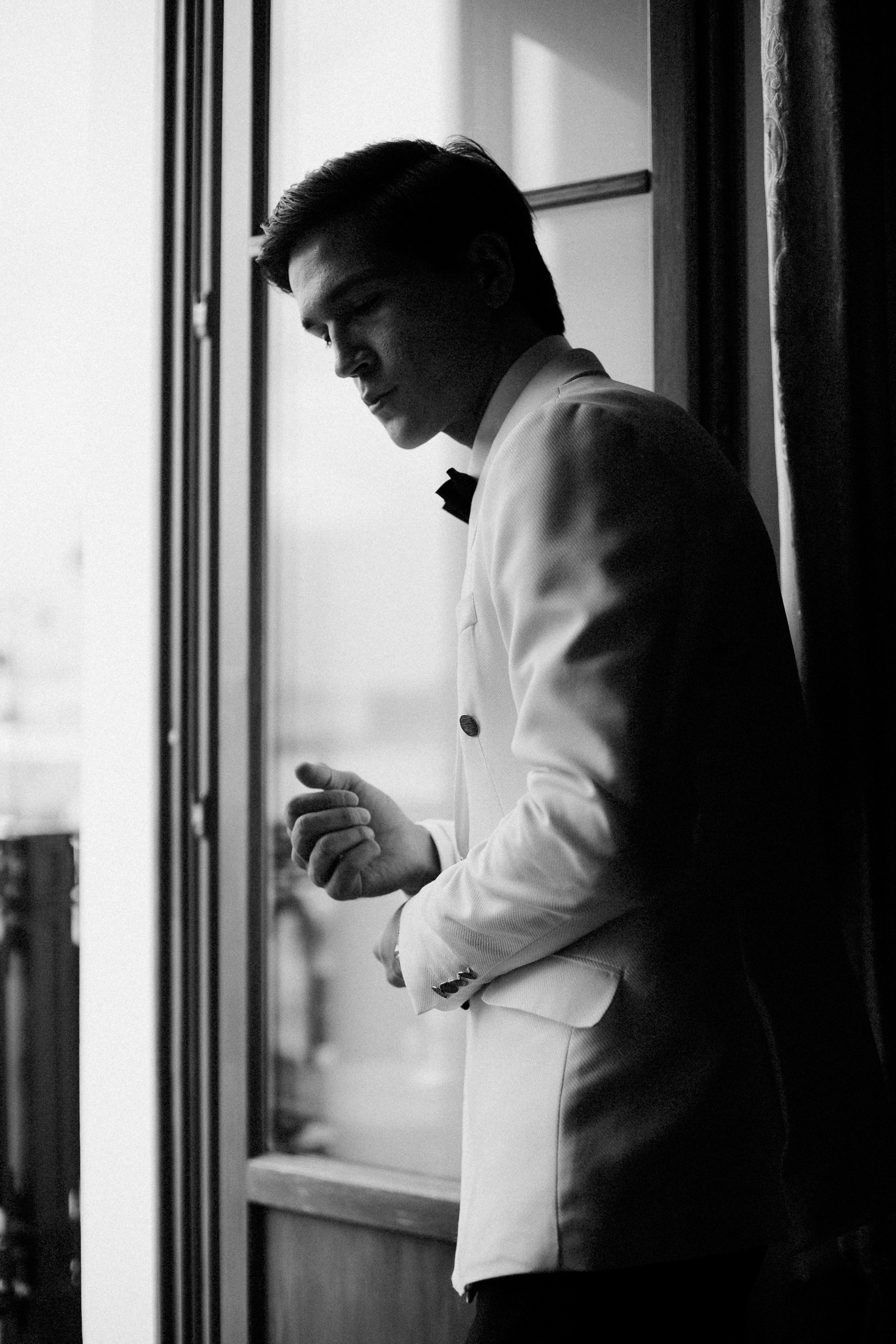 Чёрно-белая фотография жениха у окна — атмосферная свадебная съёмка в Trezzini Palace Hotel СПб