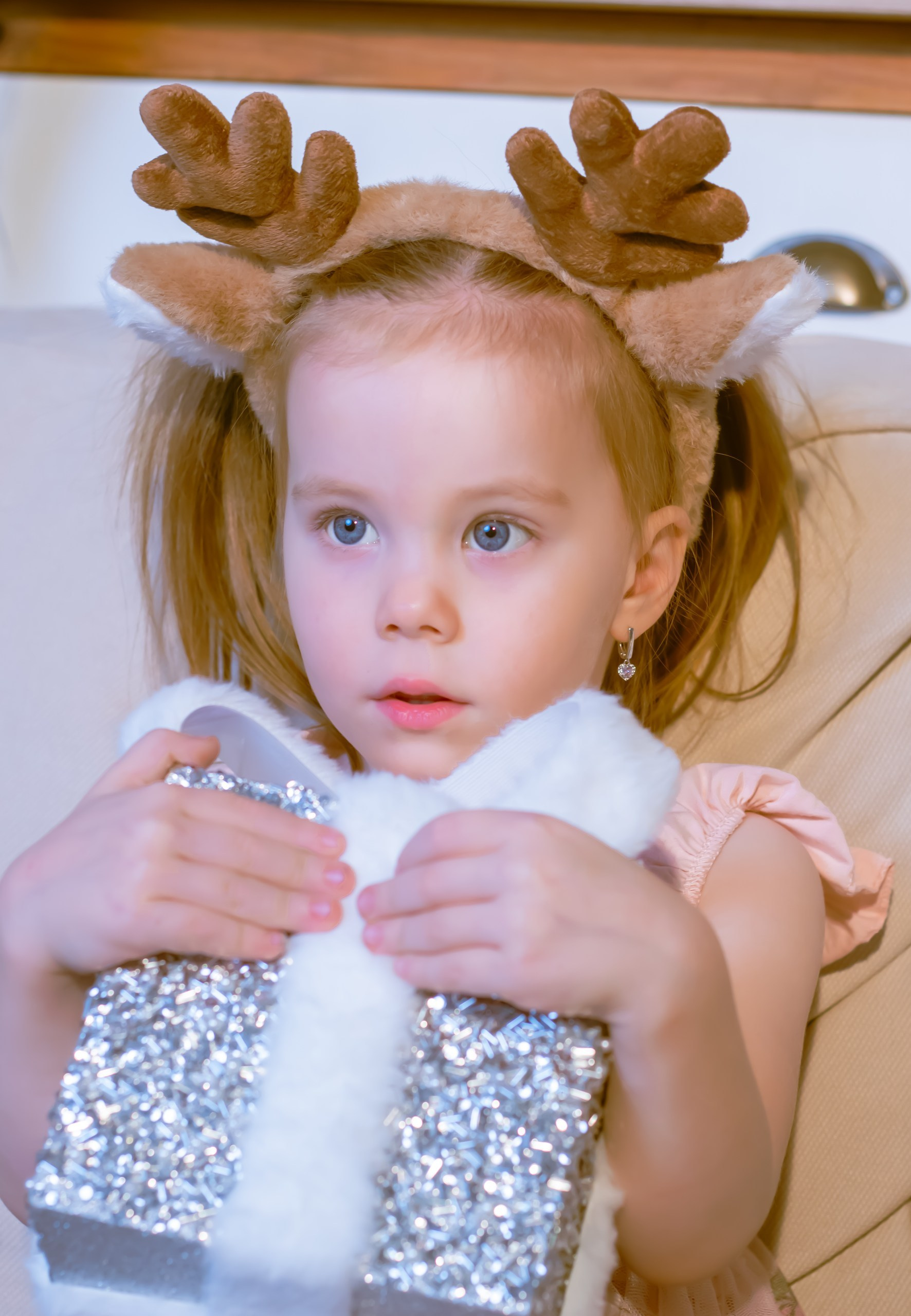 Маленькая девочка с подарком в руках на фоне ёлки, новогодняя съёмка, фотограф Карасёва Елена