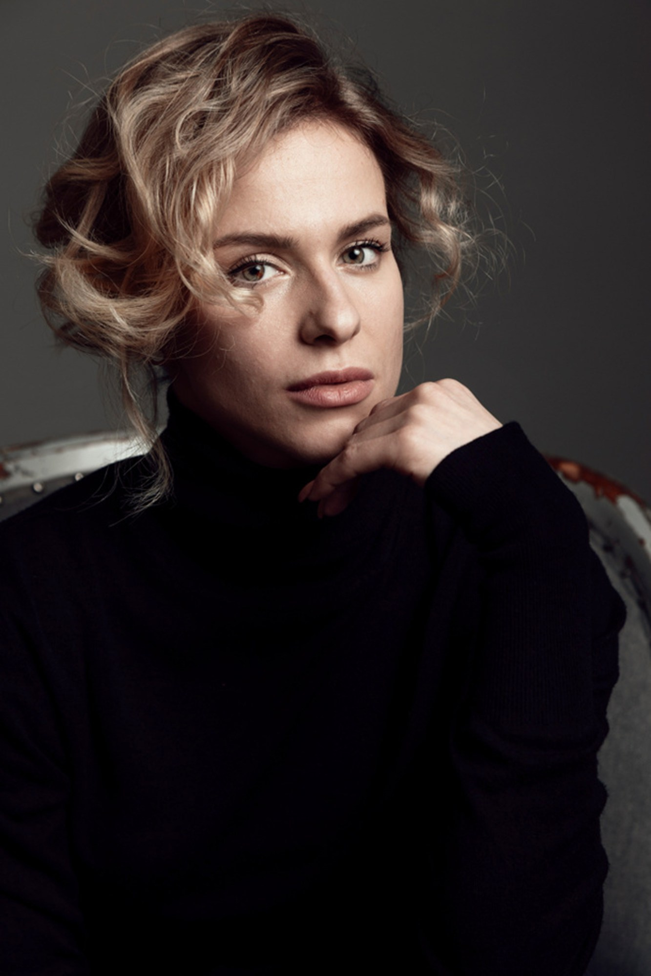 Editorial portrait of a woman in a black turtleneck with soft natural expression, photographed for personal branding