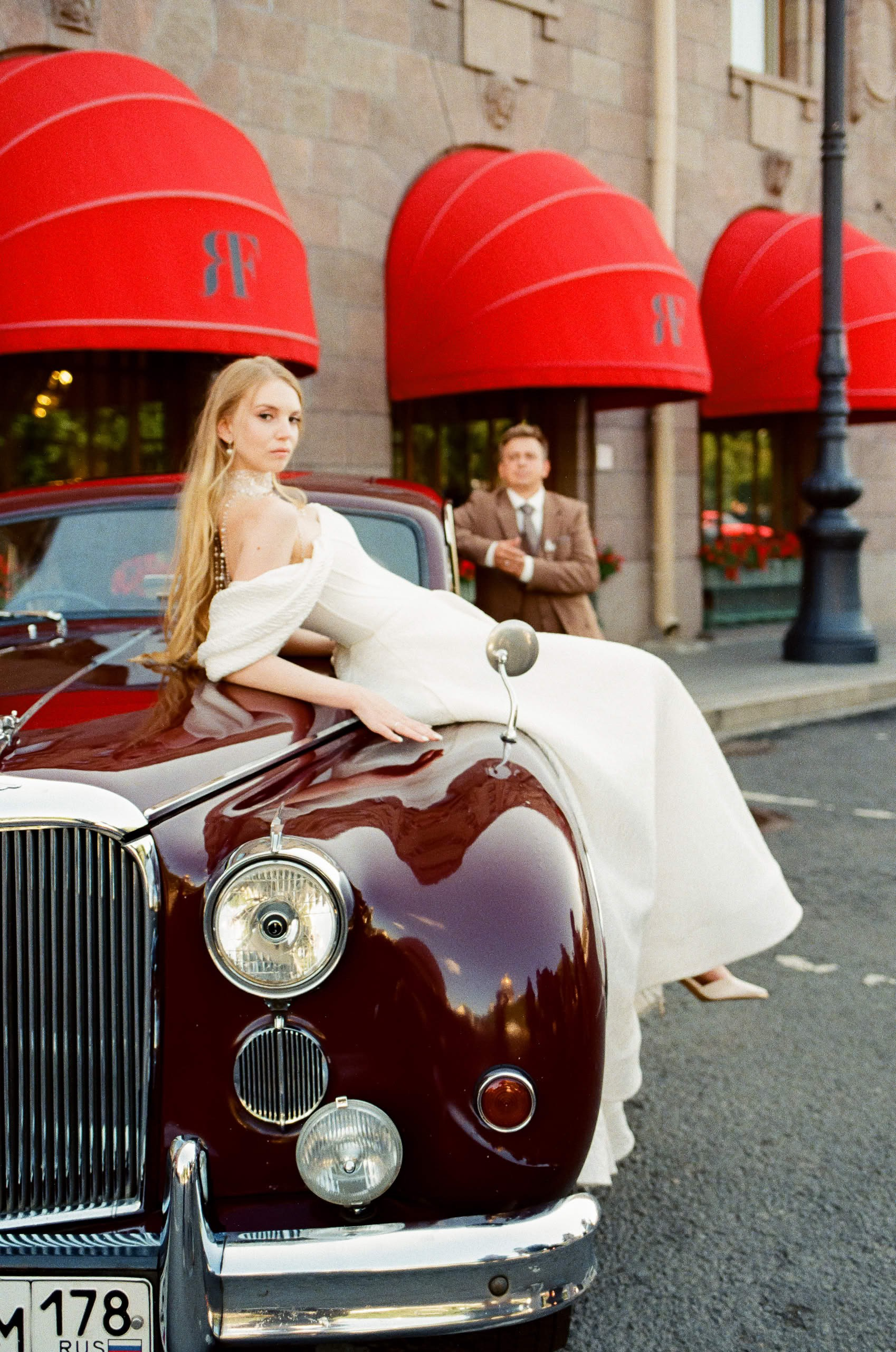 Жених и невеста у ретро автомобиля Jaguar 1959 года возле отеля Four Seasons Lion Palace.