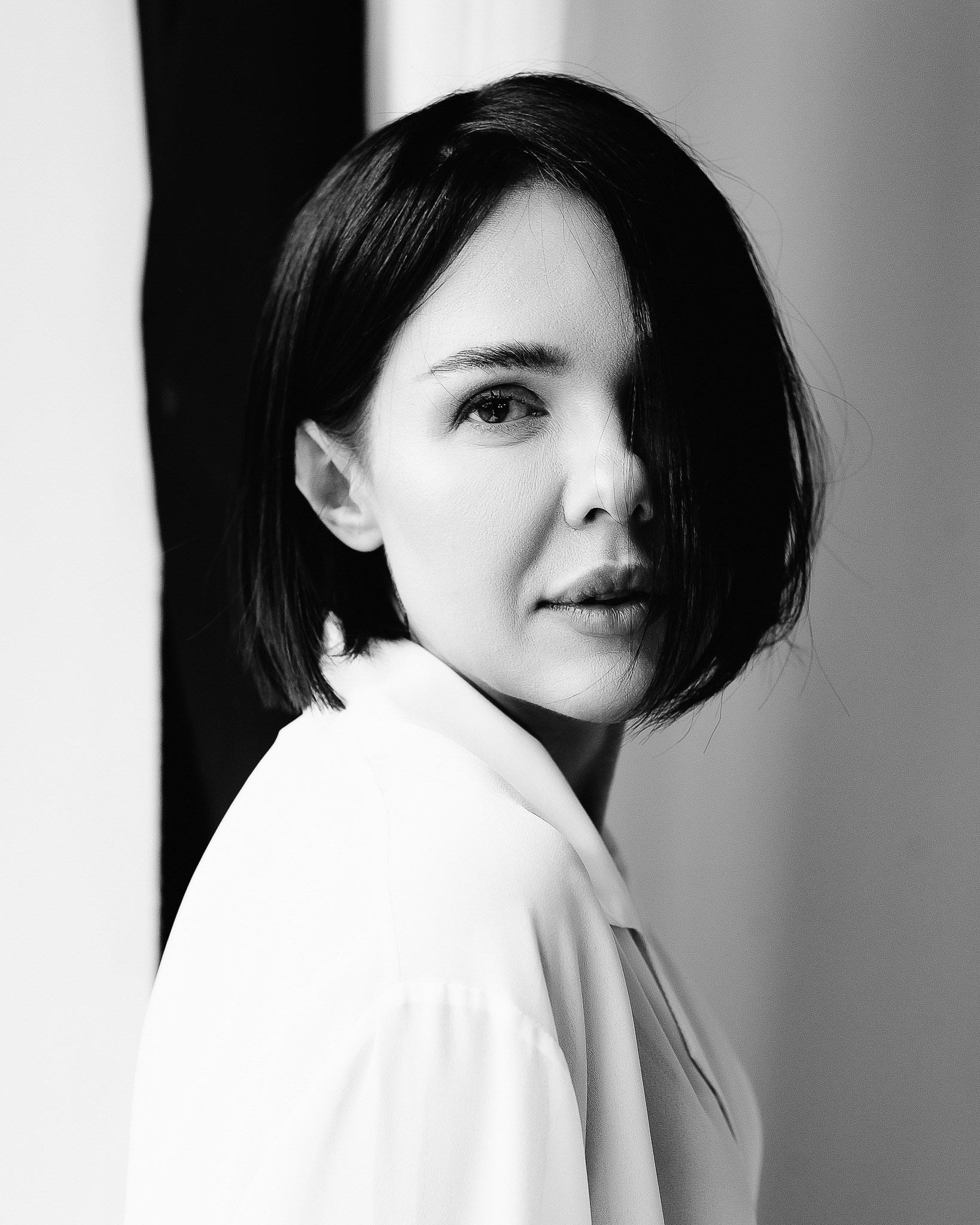 Фотограф Роман Романов — черно-белый портрет девушки в студии в белом. Волосы каре