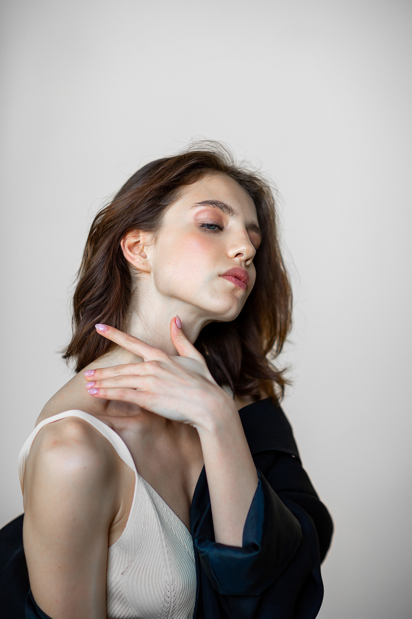 расслабленный портрет девушки в белом топе и черном пиджаке