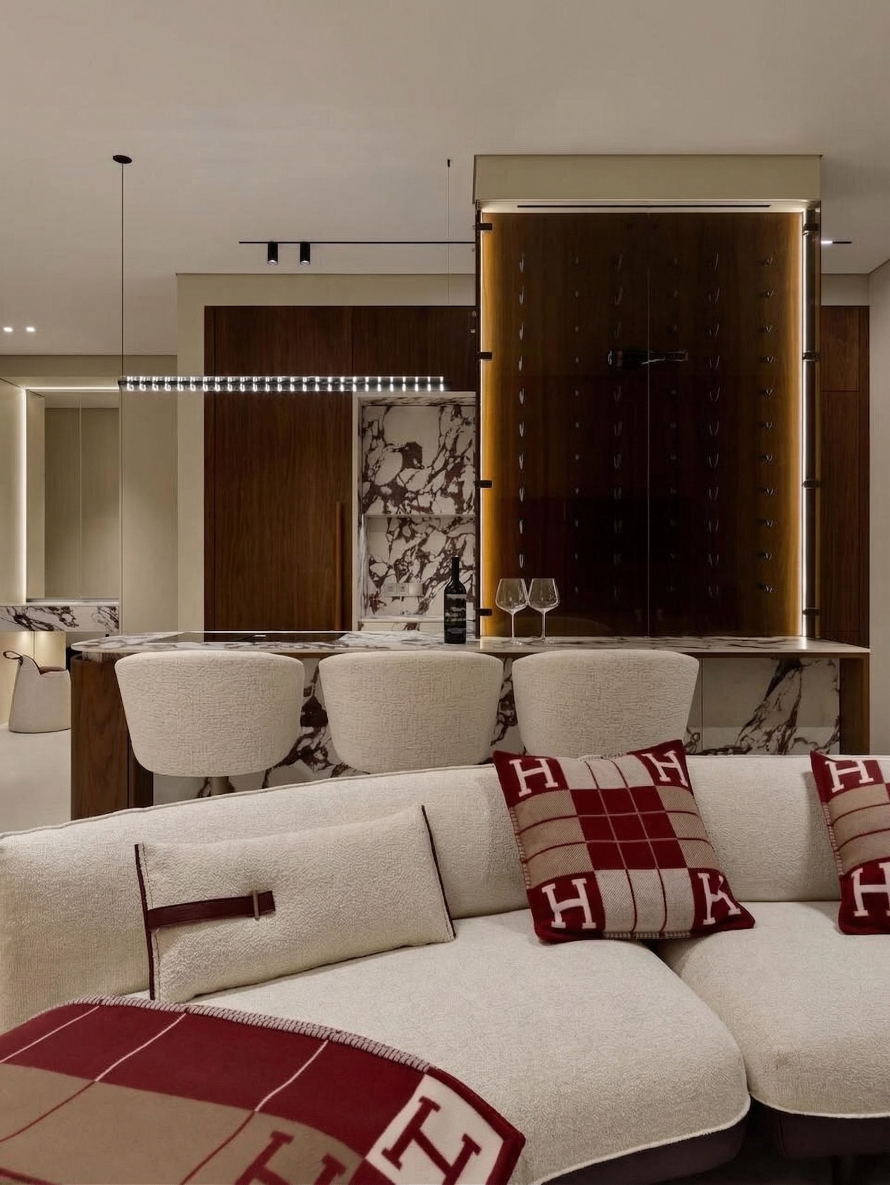 Современный интерьер гостиной от Валерии Котович: многоплановое зонирование, диван букле, остров из натурального камня и винная витрина с подсветкой в квартире 85 м².