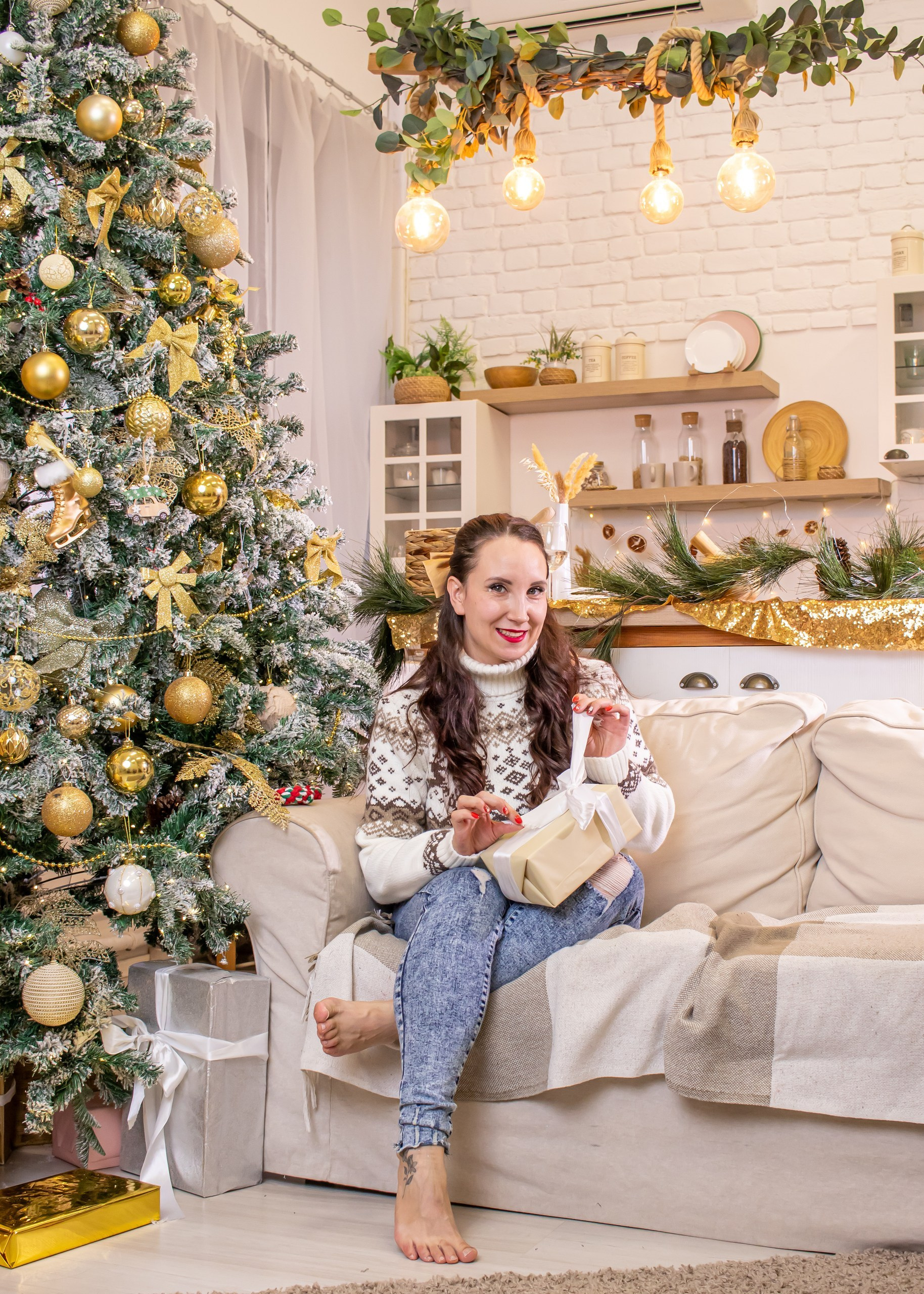 Женщина позирует в светлой гостиной с украшенной ёлкой и гирляндами, новогодняя фотосессия, фотограф Карасёва Елена
