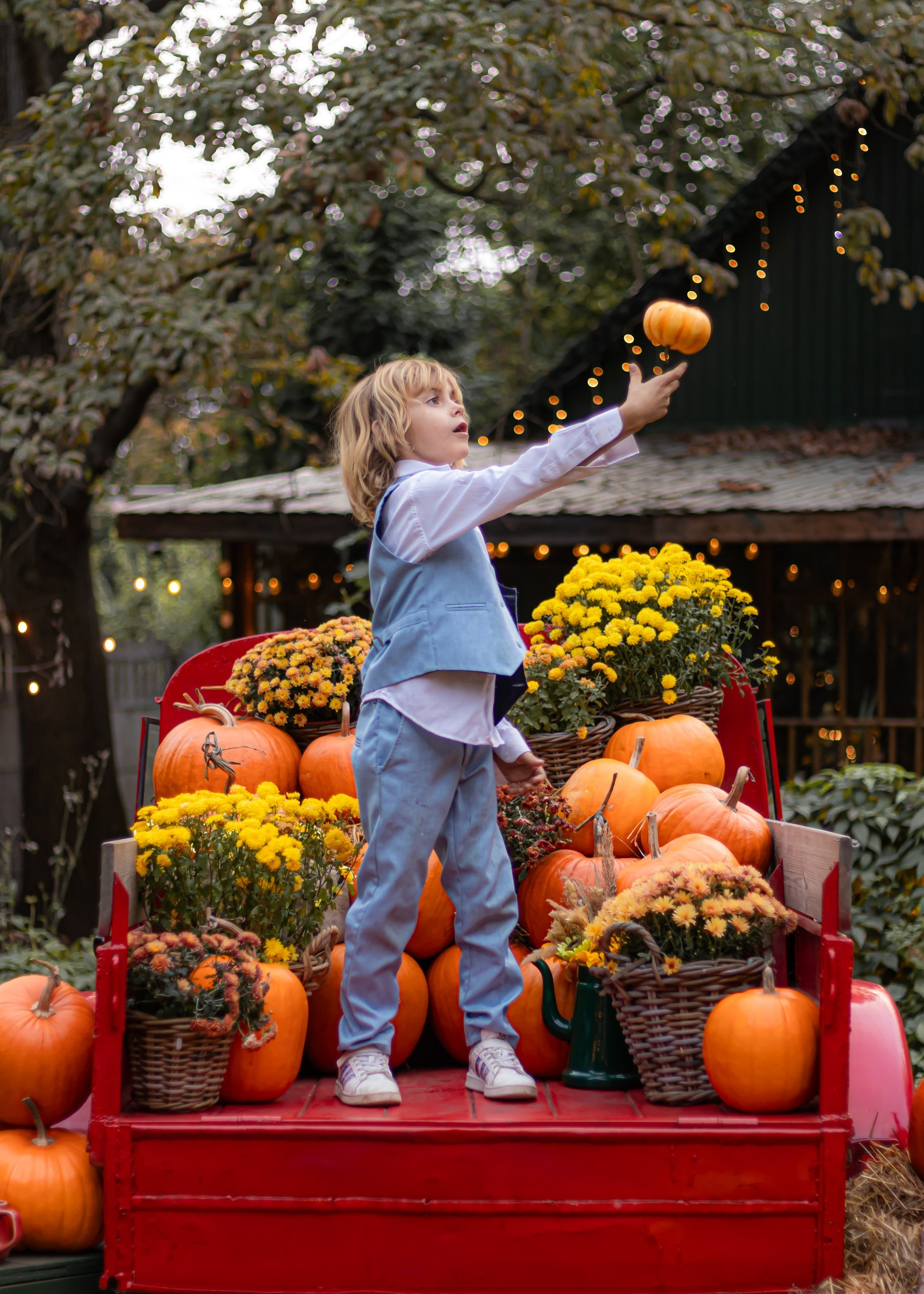 Ребёнок позирует рядом с тыквами на уютной осенней фотозоне — фотограф Карасёва Елена