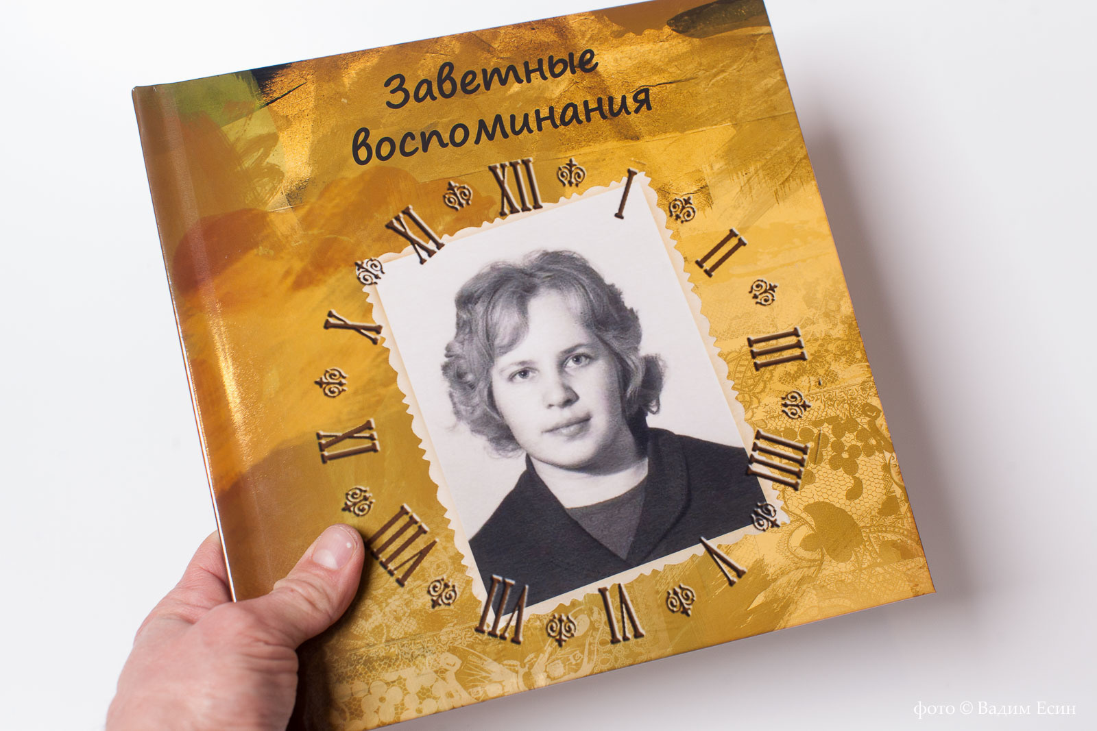 Квадратная фотокнига с черно белым портретом женщины.