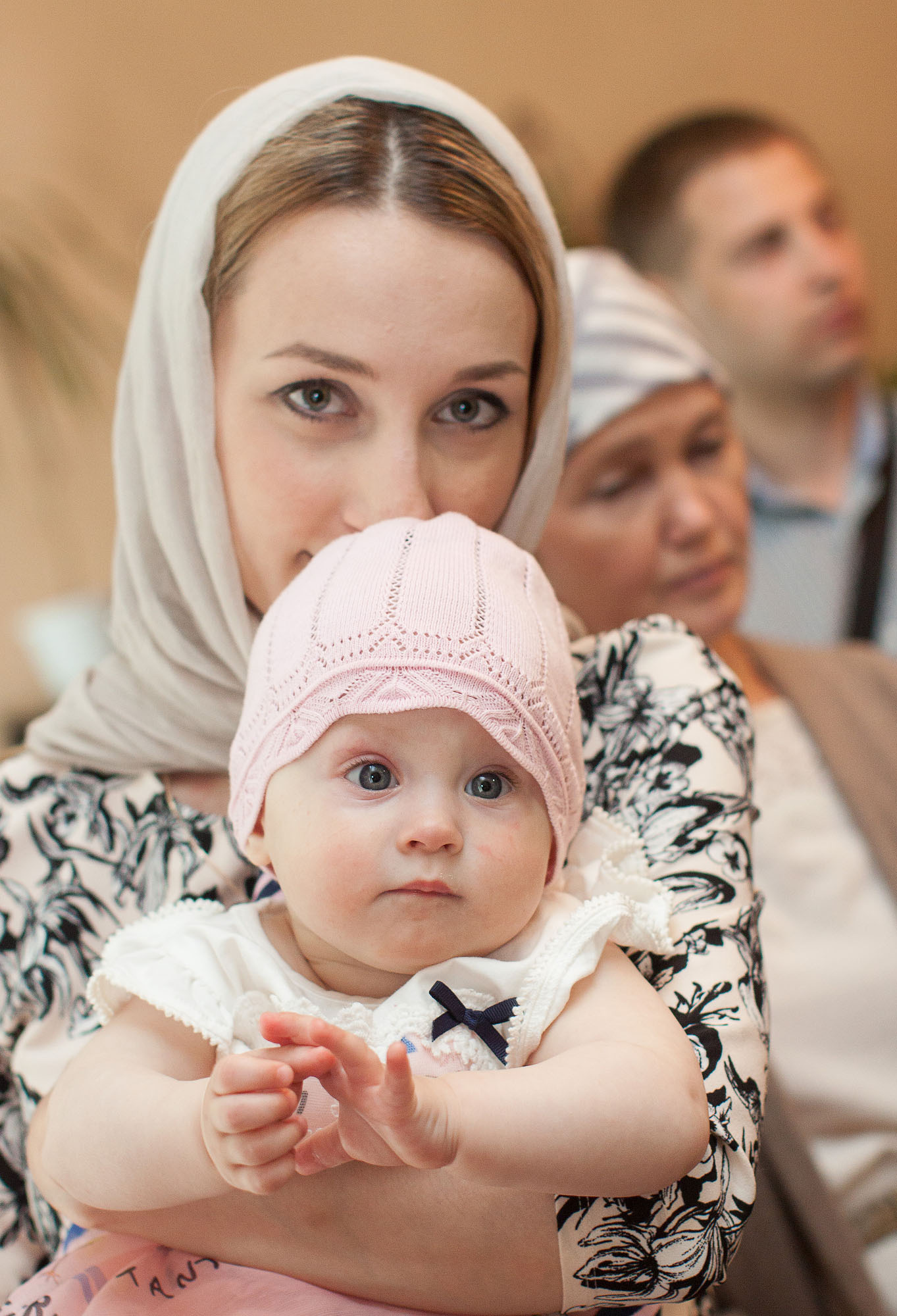 Малыш в розовой шапочке на руках у мамы в платке