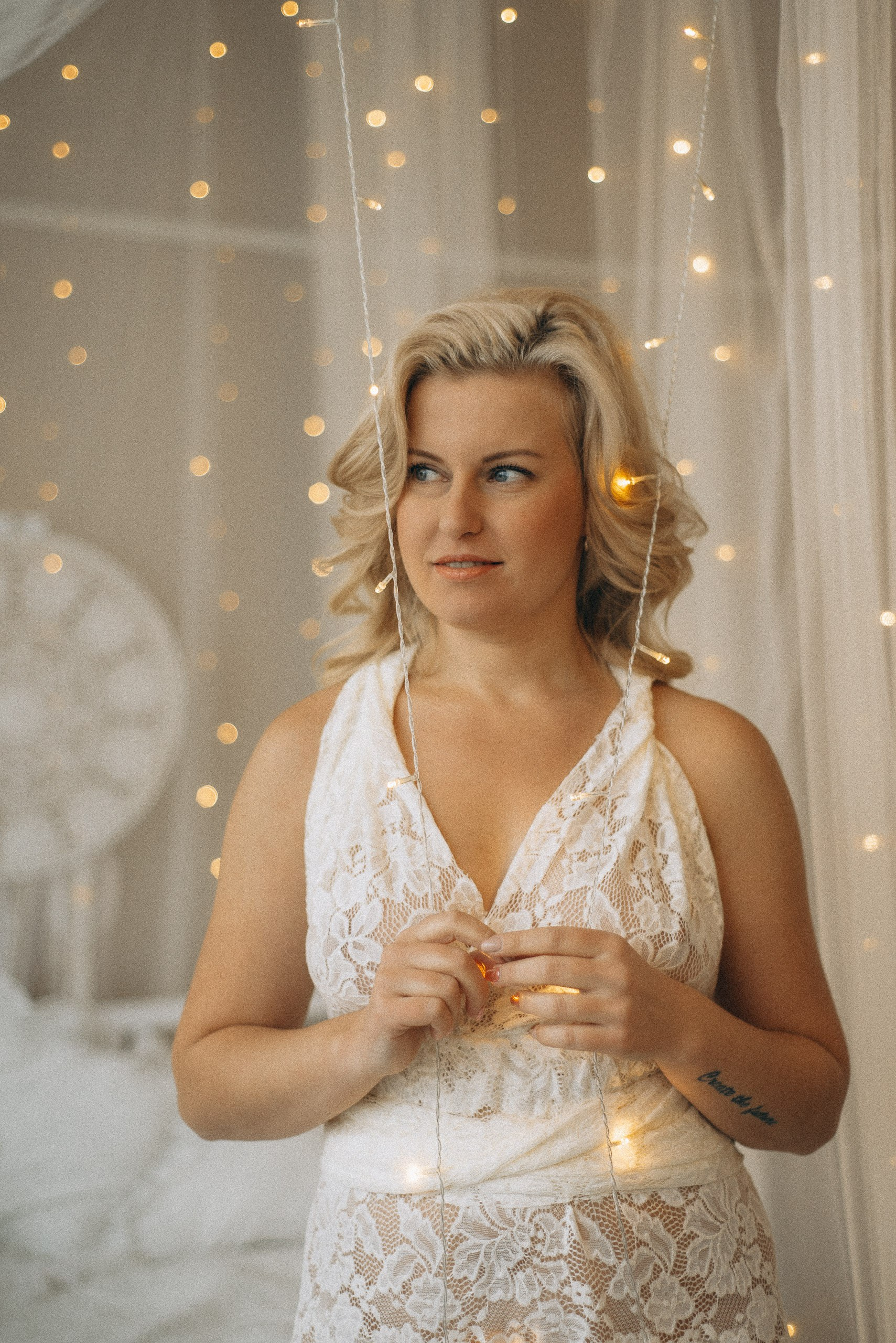 Крупный план Натали Каролин в белом кружевном платье. Акцент на деталях кружева, естественном макияже и нежности образа. Студийная съемка в Новосибирске