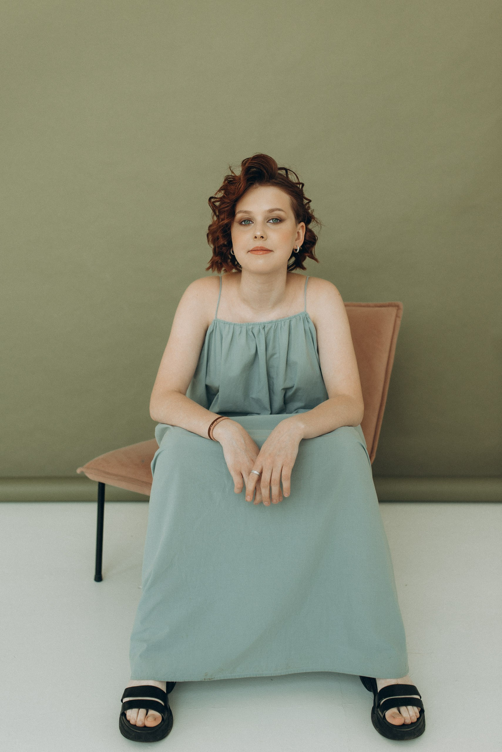 Драматичный портрет девушки на тёмном фоне. Контрастный свет, акцент на взгляде и рыжих волосах. Студийная фотосессия в Новосибирске