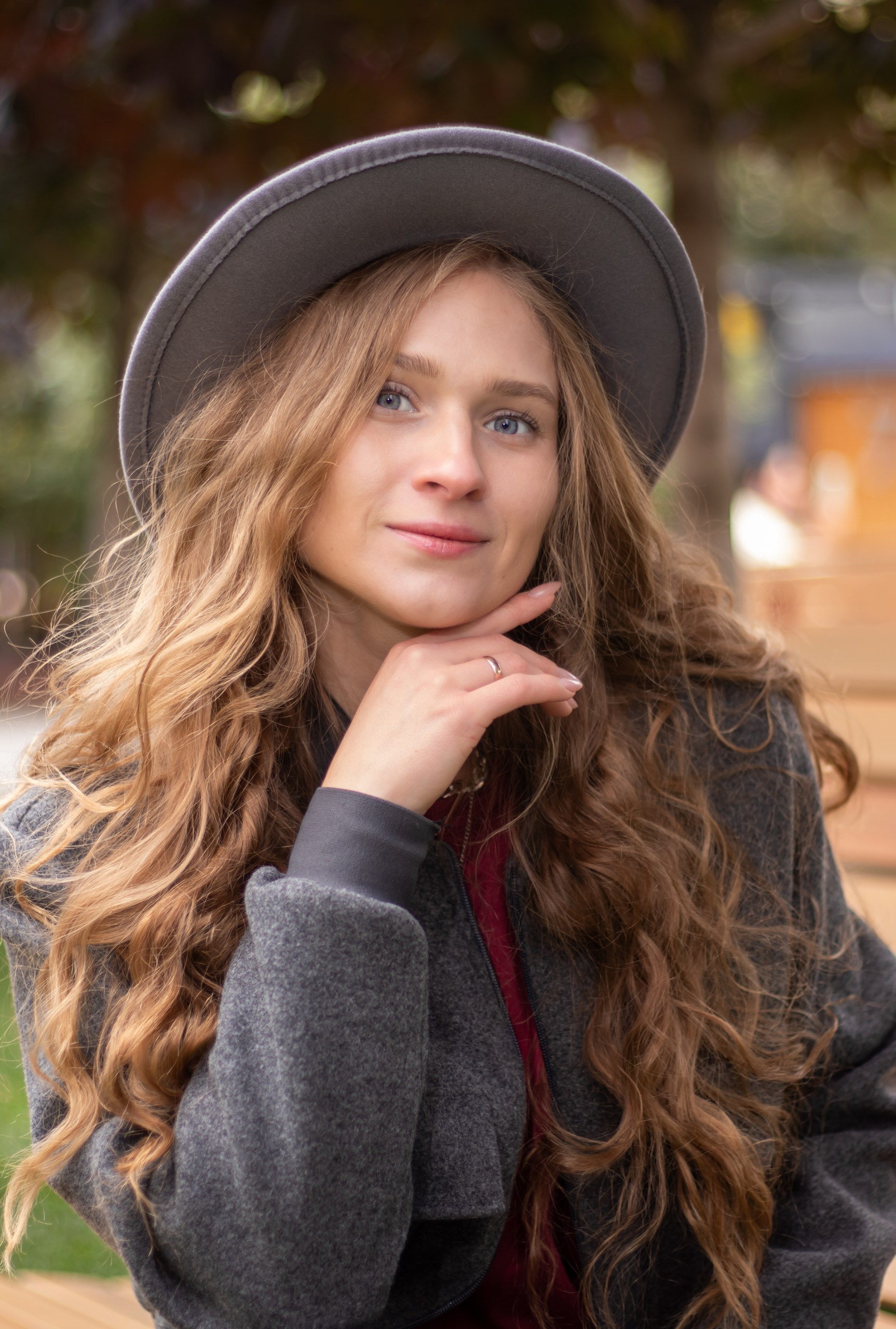 Девушка сидит на лавочке в парке, осенняя съёмка на природе