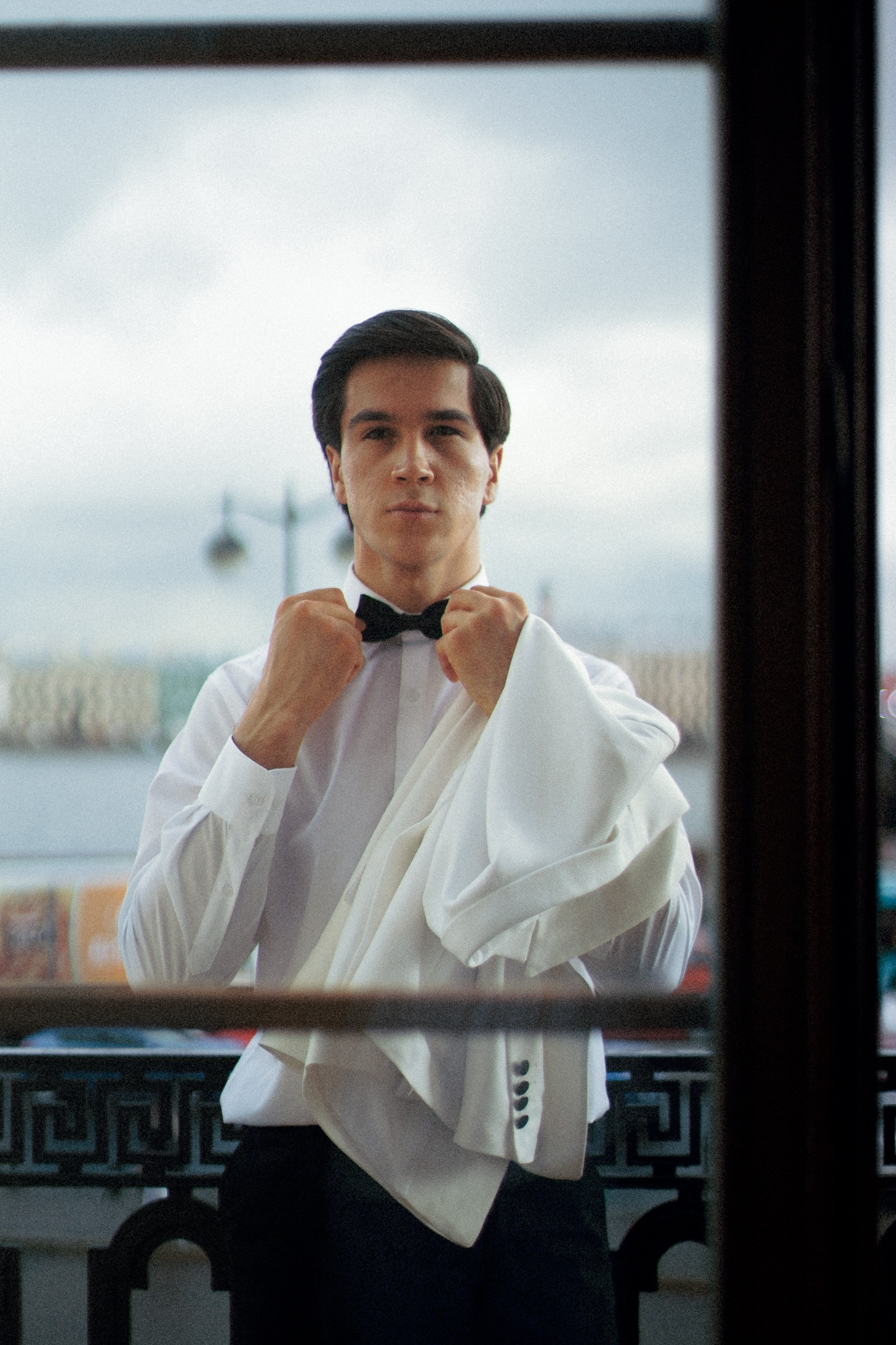 Цветной портрет жениха у окна с видом на Неву — свадебная съёмка в Trezzini Palace Hotel, Санкт-Петербург