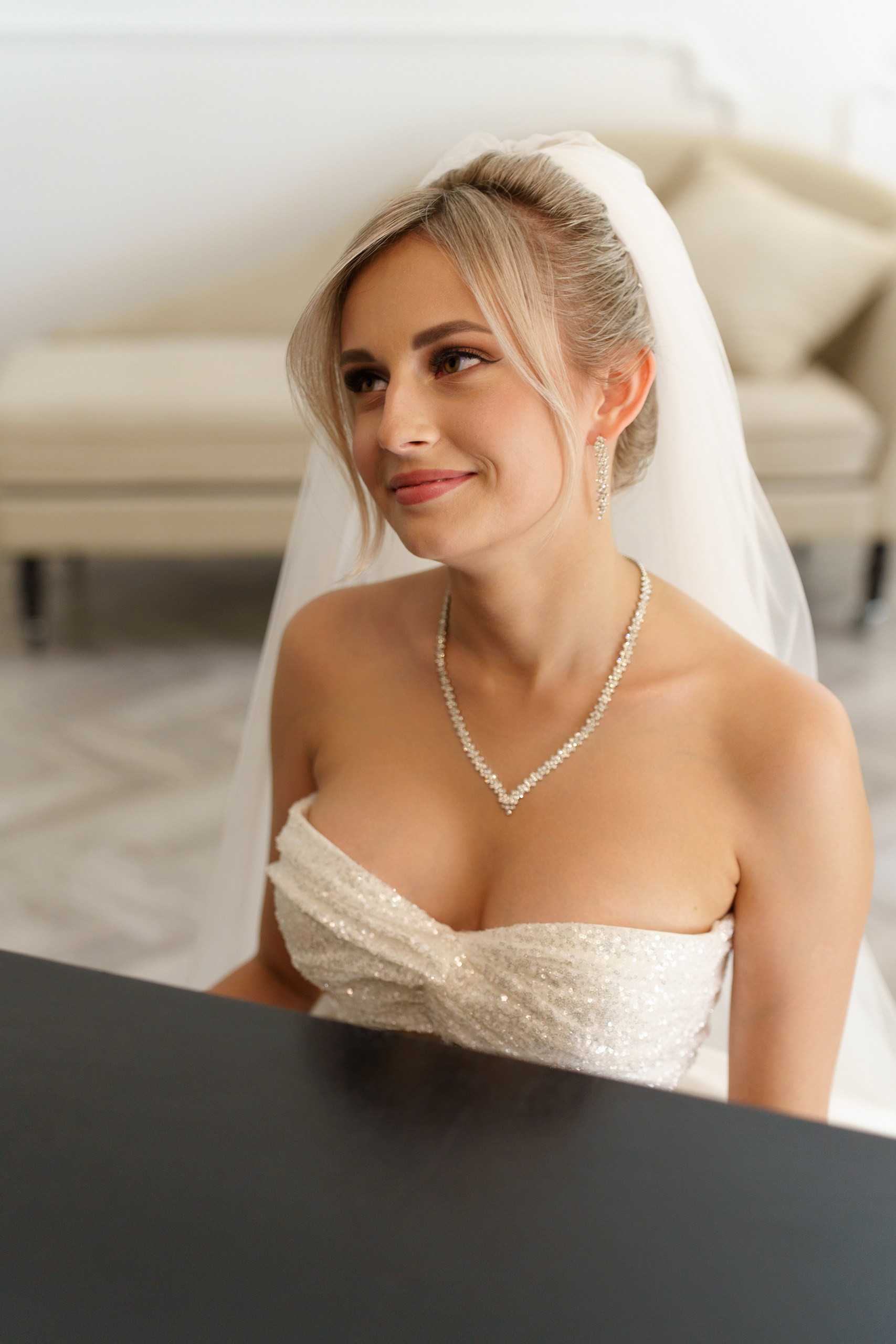 Портретная фотография невесты в свадебном образе: белое платье без бретелек, фата, колье и серьги. Невеста выглядит спокойной и счастливой | портреты молодоженов Екатеринбург