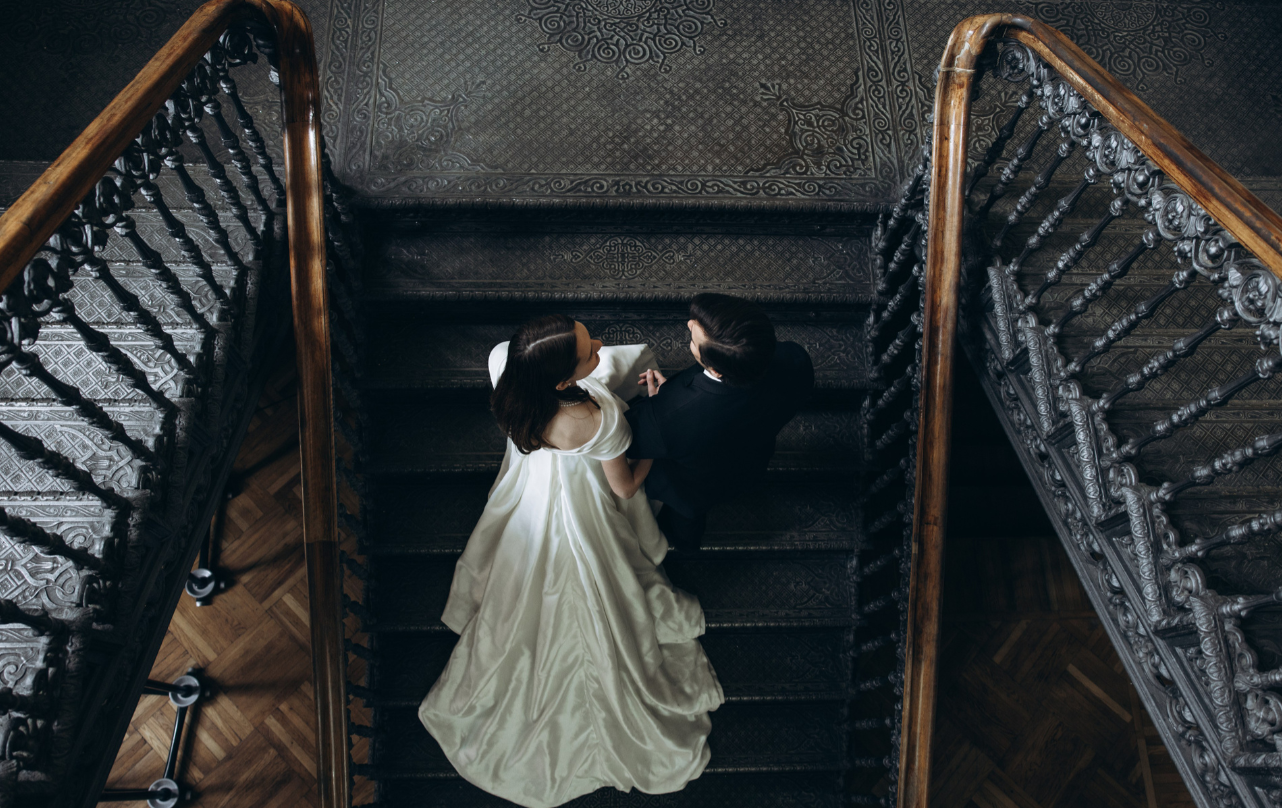 Жених и невеста сидят на старинной лестнице, обнимаются. Атмосфера уютная, загадочная.