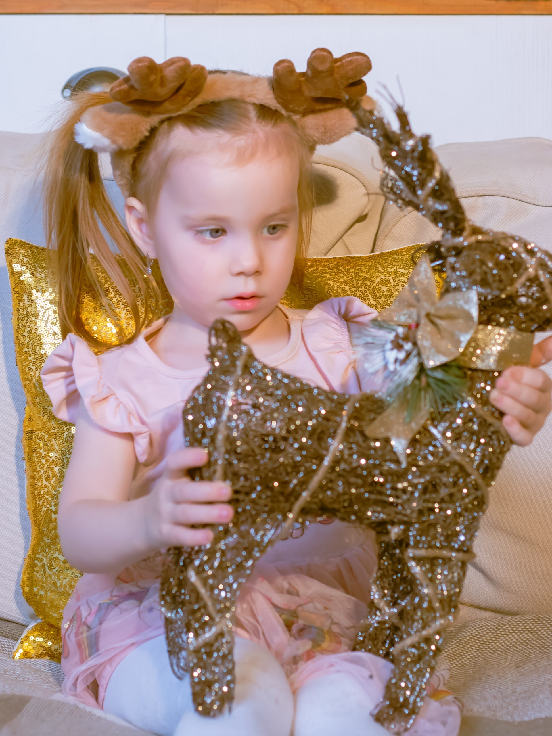 Девочка играет с рождественскими украшениями за кухонным столом, новогодняя съёмка, фотограф Карасёва Елена