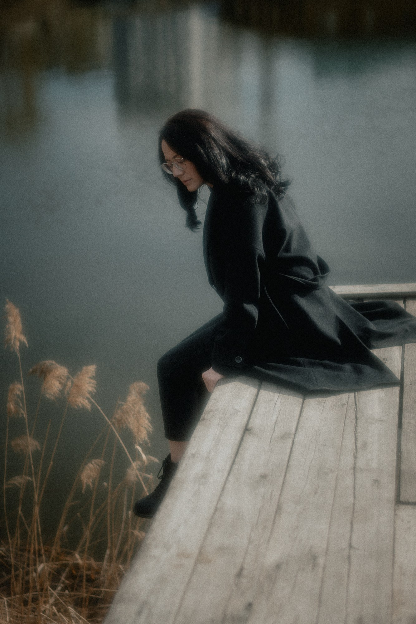 Девушка у воды на деревянном мостике, меланхоличное настроение