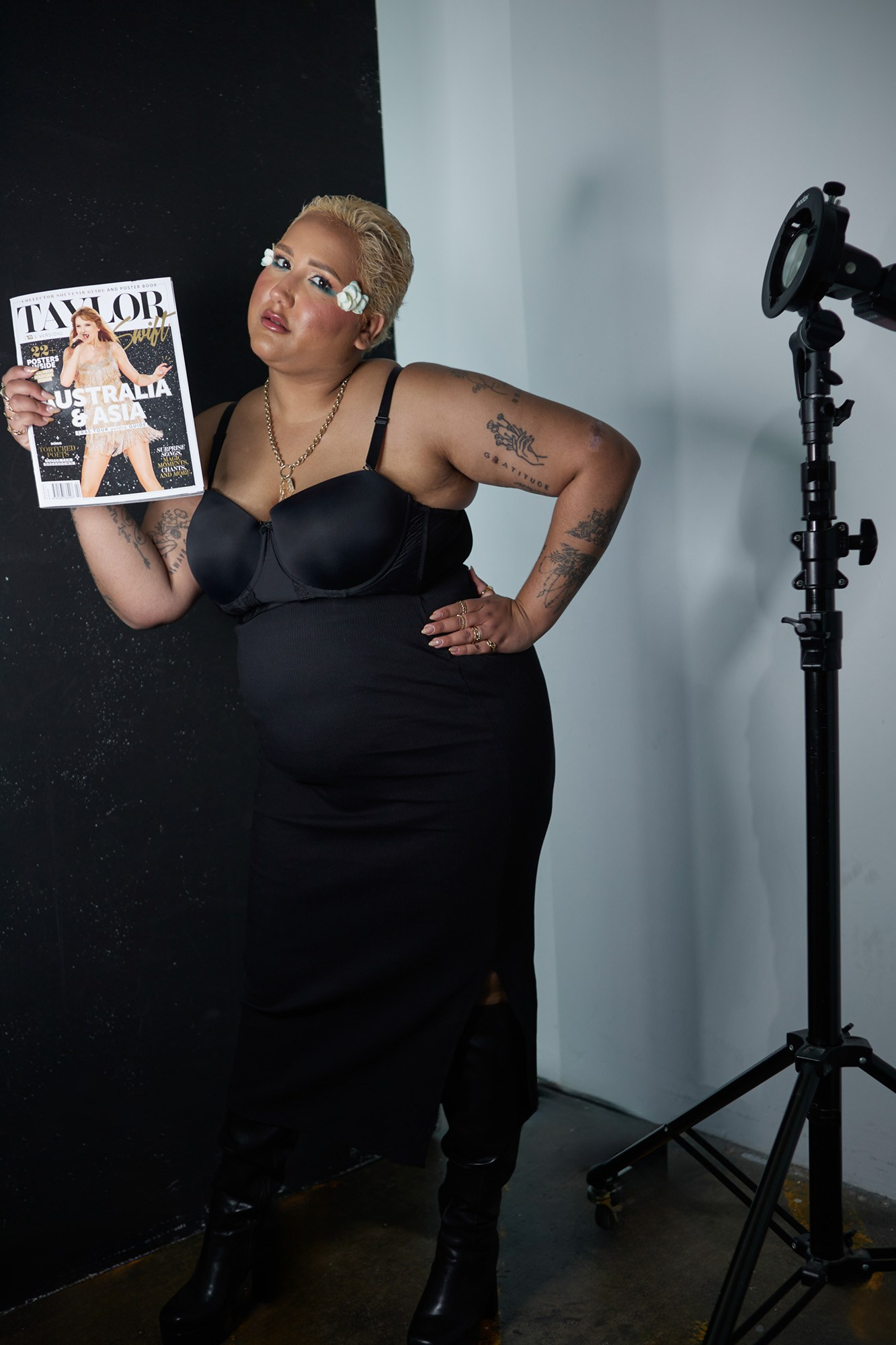 Fashion portrait of Doriane Cannon in a black dress holding an issue of Taylor Magazine during a model portfolio photoshoot.