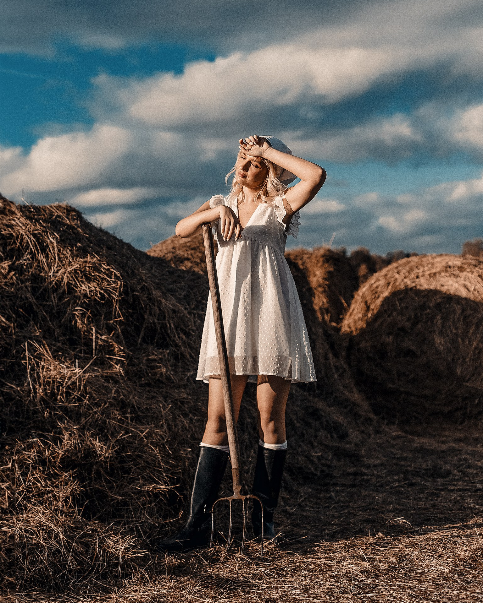 Фотосессия в стиле крестьянки на ферме со стогами сена Казань, девушка в образе крестьянки и вилами позирует на ферме с сеном