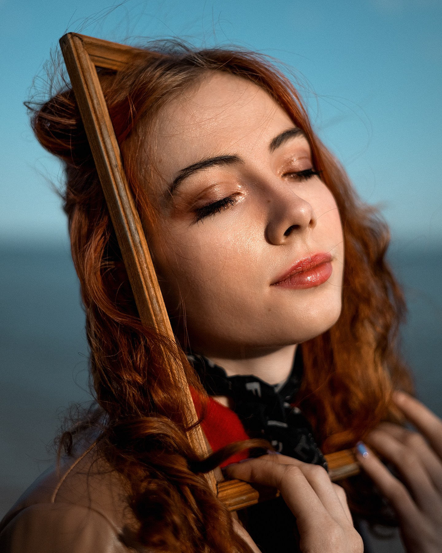 Молодая девушка позирует с картинной рамкой, творческая съемка с картинной рамкой