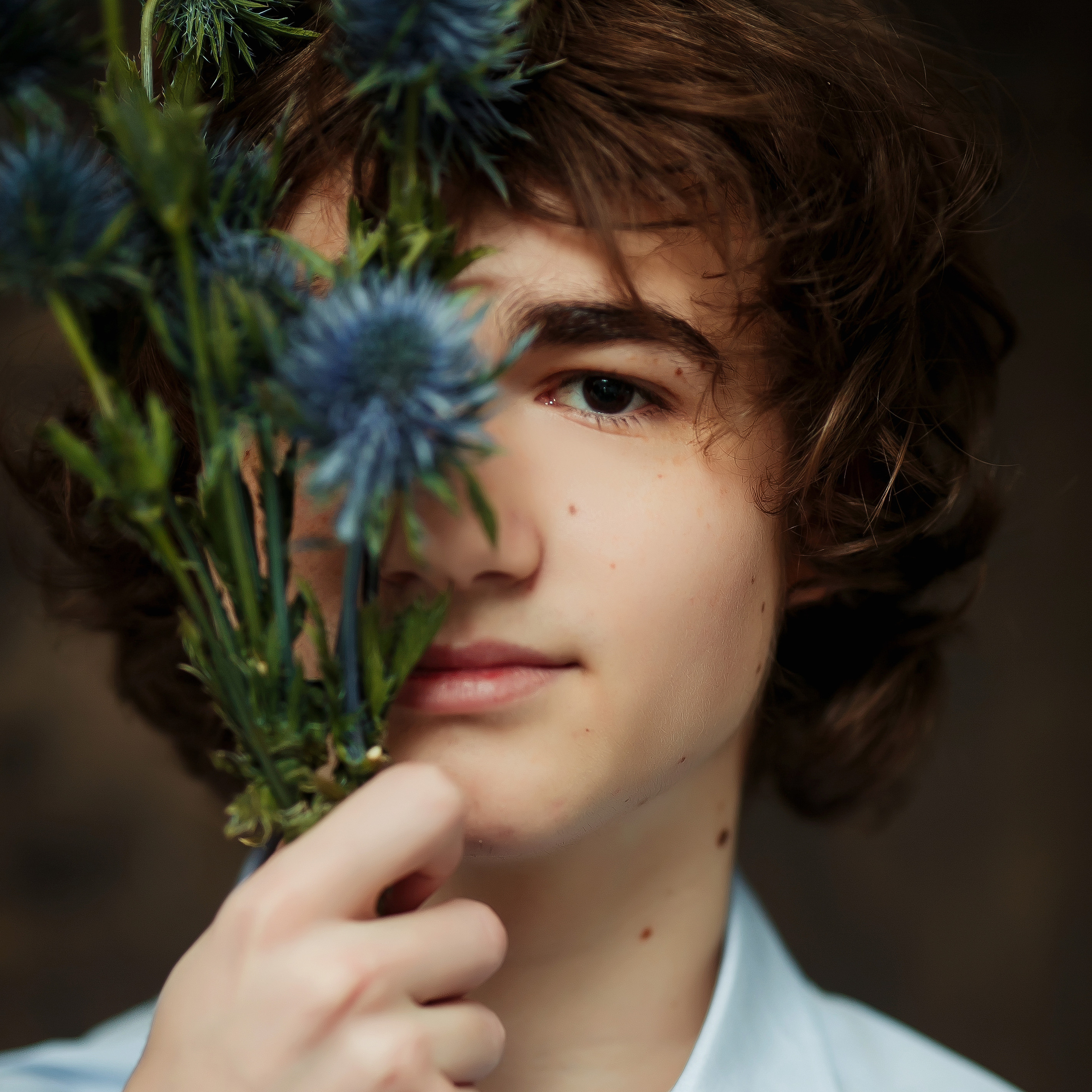 Мальчик закрыл себе по-лица букетом с колючками. Художественная фотография от фотостудии Вышка.