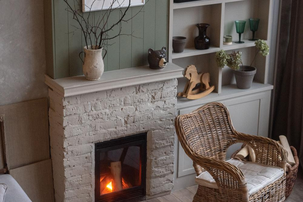 плетеное кресло возле горящего камина