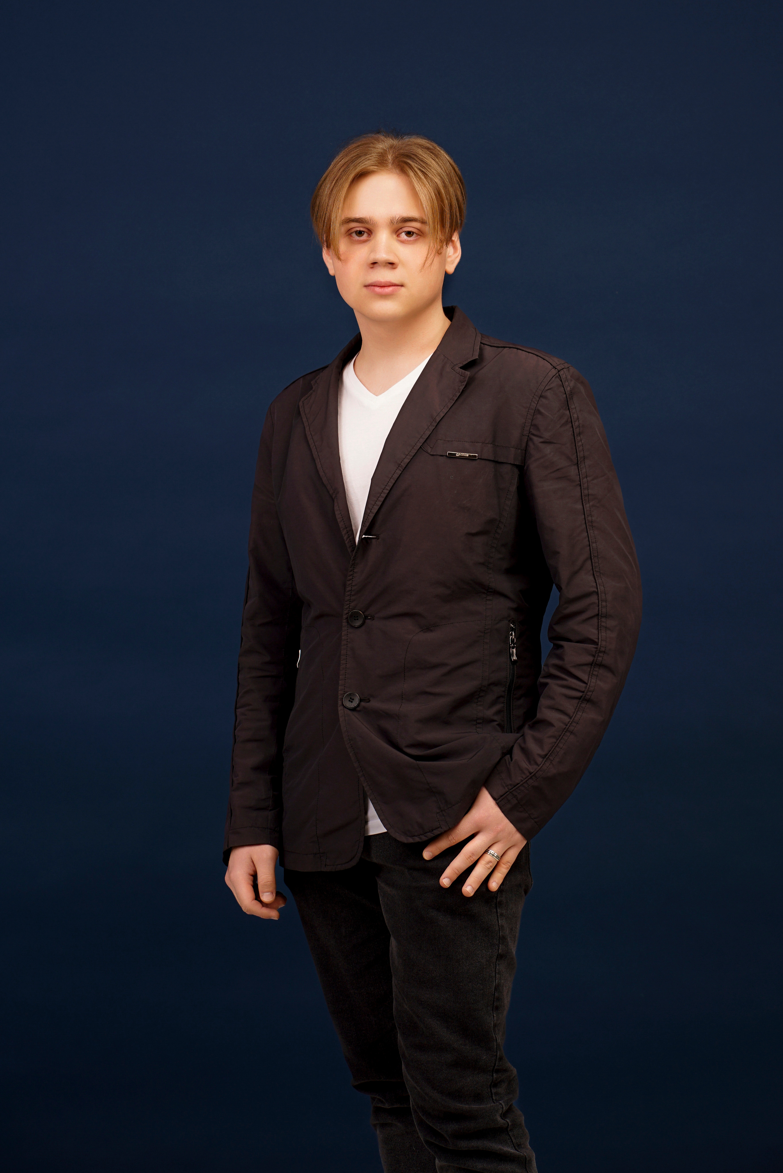 Портрет молодого человека в студии на синем фоне