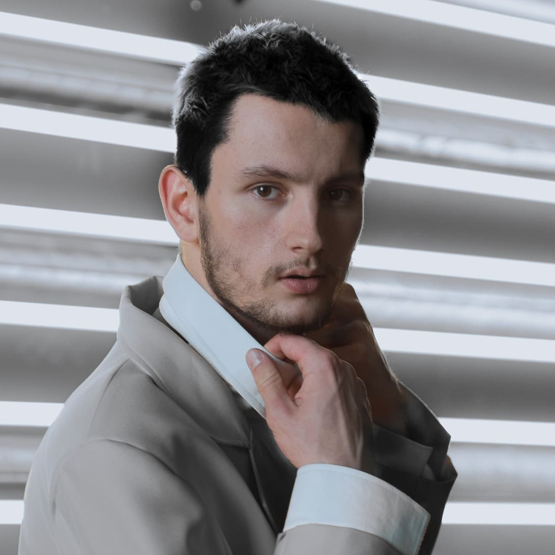  Мужчина в костюме, стоящий перед рядом ламп