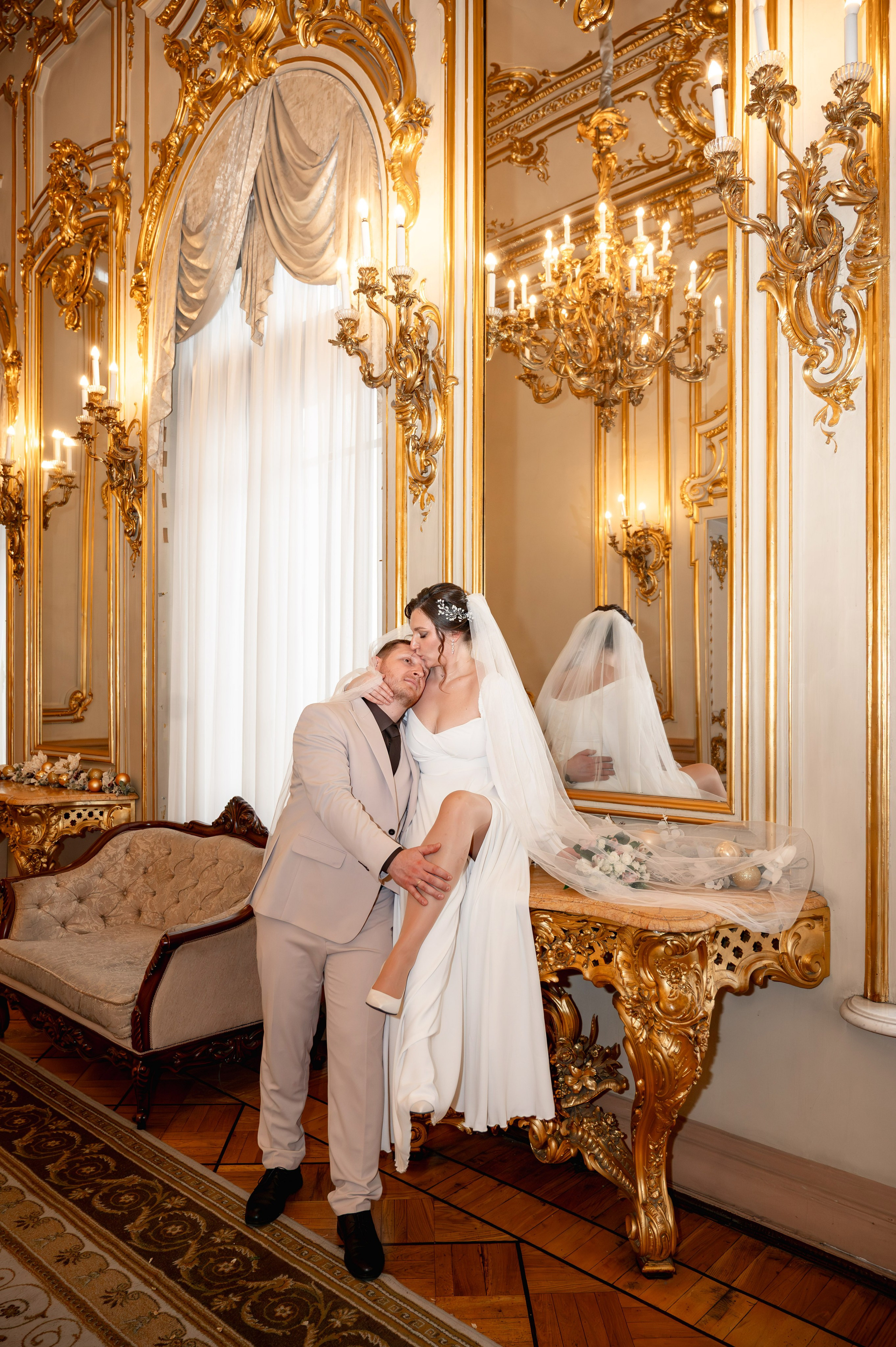 Невеста сидит на мраморной столешнице во дворце бракосочетания и прижимает к груди любимого