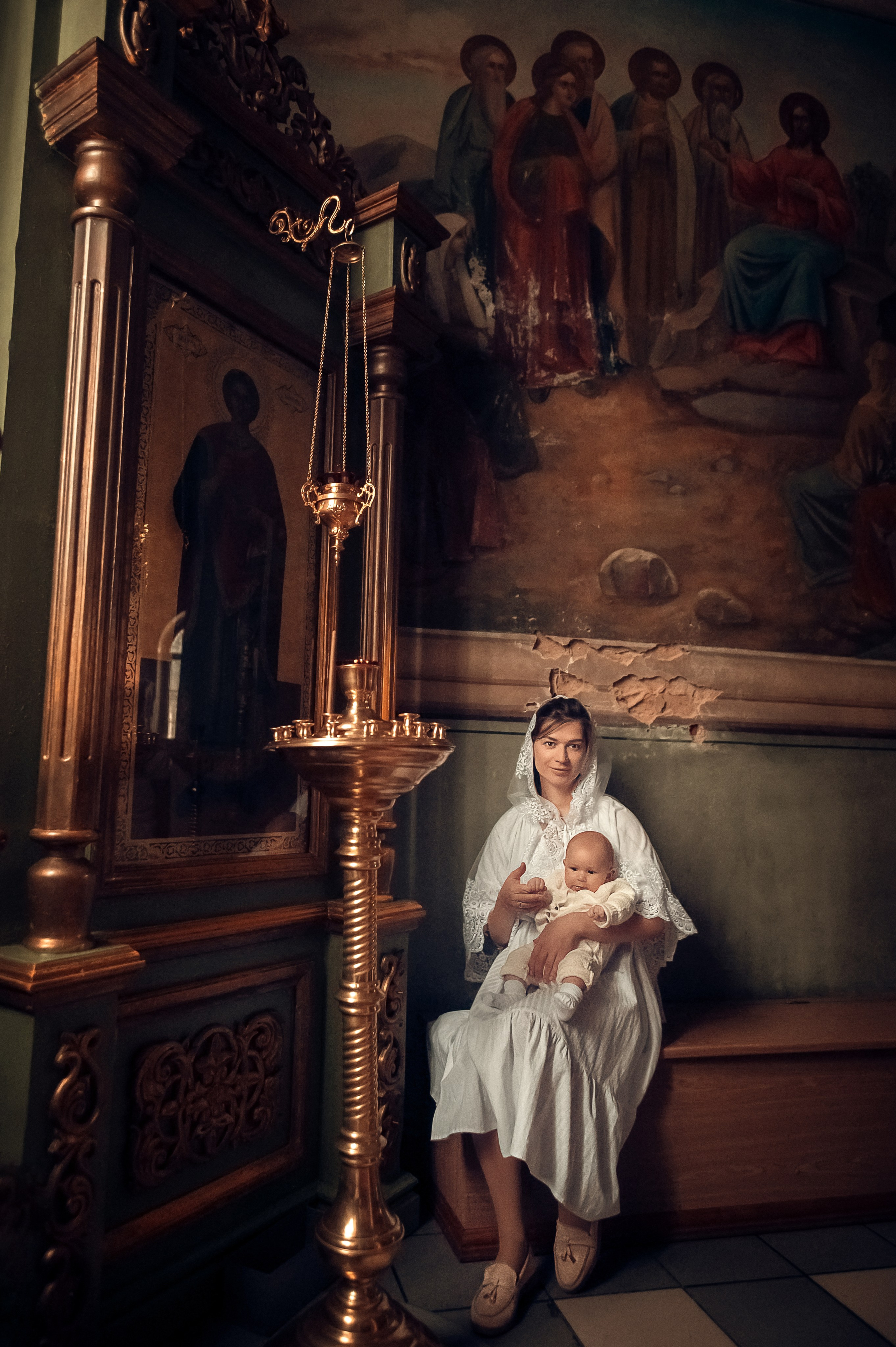 Профессиональная видеосъемка венчания и крещения в Москве: таинство в православном храме Красивая видеосъемка крещения ребенка в церкви Москвы: крупный план младенца и священника Видеосъемка обряда венчания в храме: молодожены держат венцы над головами Услуги видеографа на крестины и венчание в Москве: эмоциональный кадр церемонии