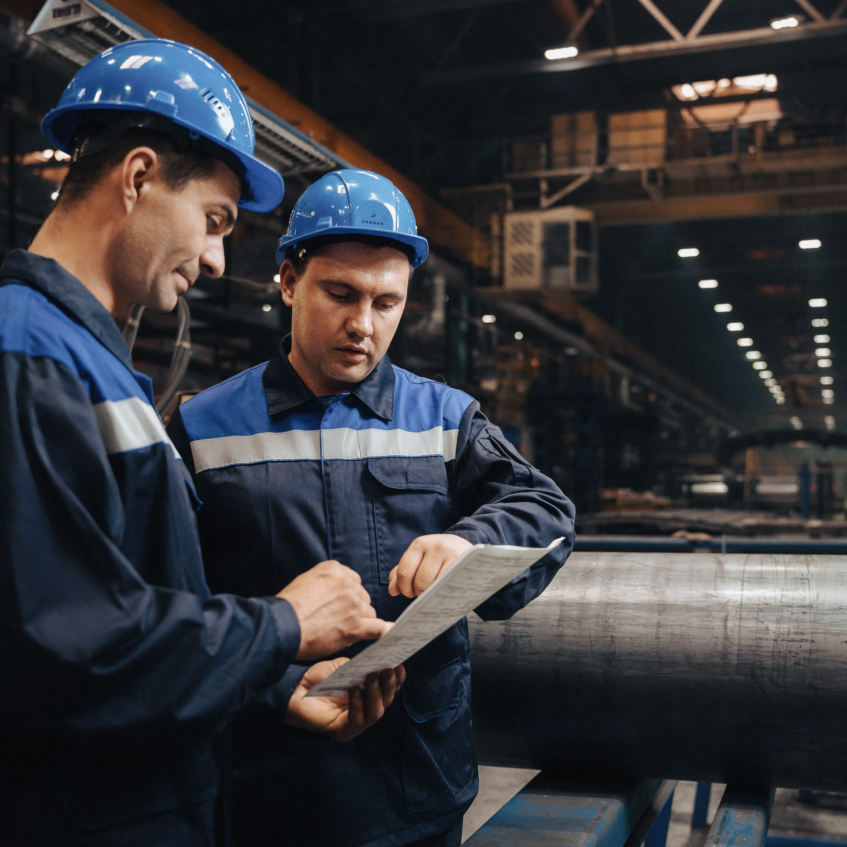 двое рабочих на фоне цеха