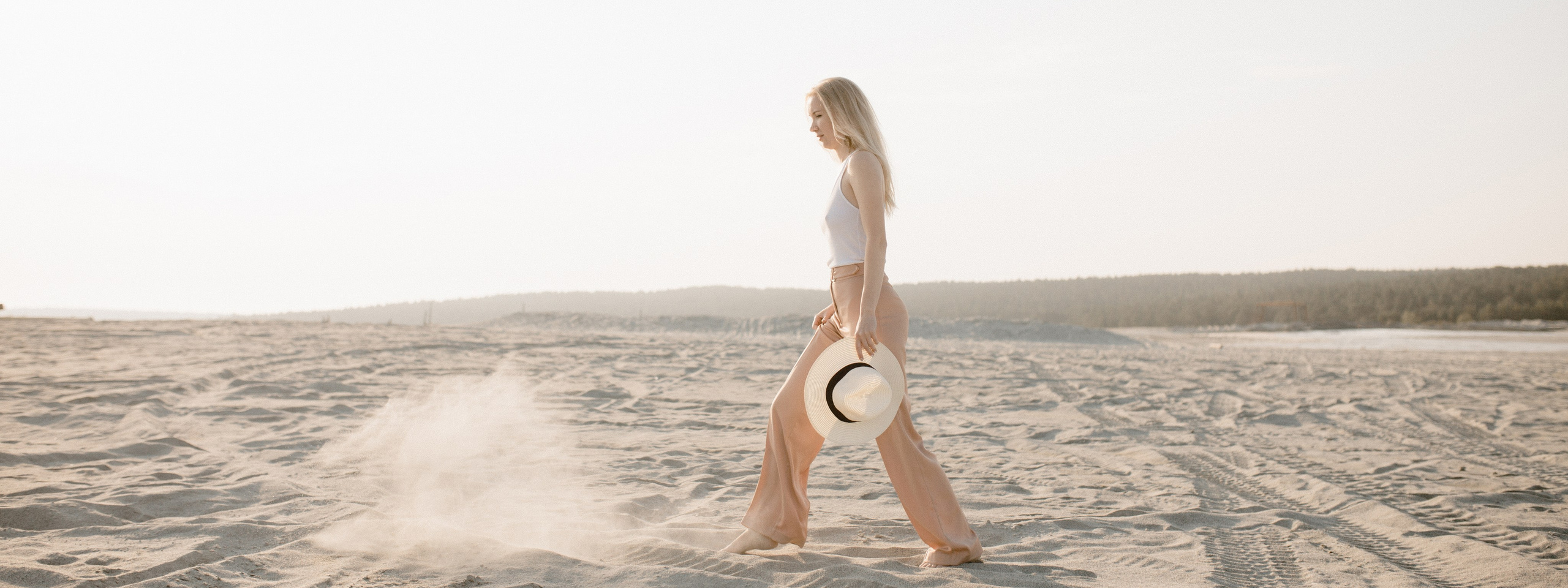 девушка идет на фотосессию с рюкзаком по песчаному карьеру Березовские пески