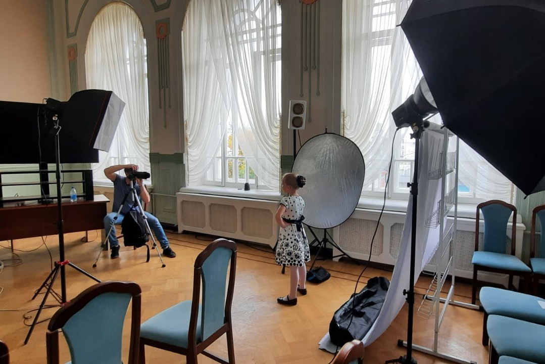 фотосъемка девочки в выездной фотостудии с зонтами и фоном