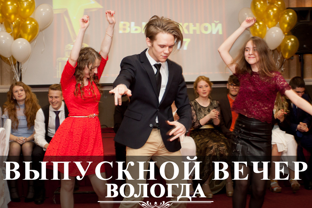 Выпускник 11 класса в черном пиджаке танцует быстрый танец с двумя одноклассницами.