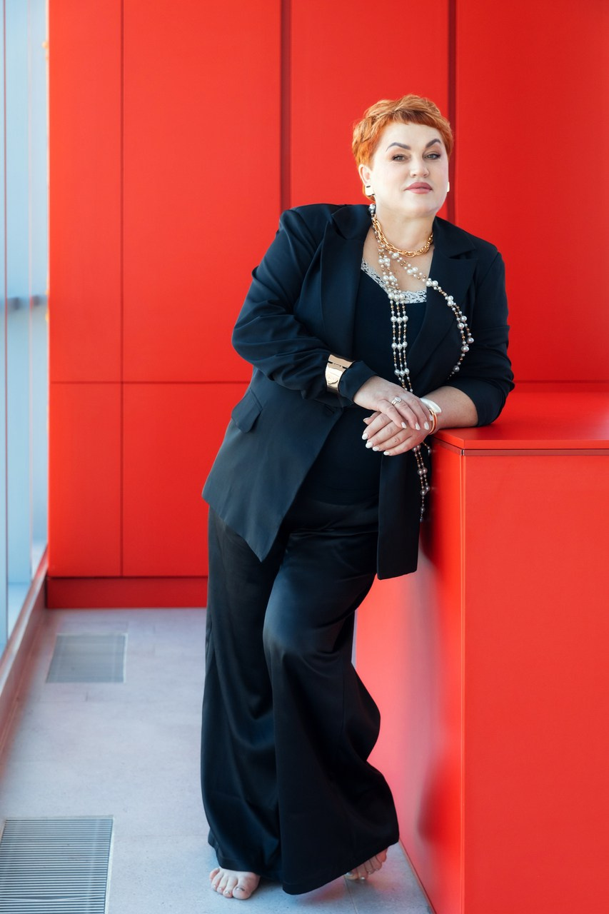 портрет женщины в полный рост стоя в студии, женщина на красном фоне