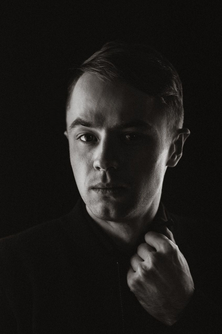 Портрет фотографа в низком ключе с одним источником света.