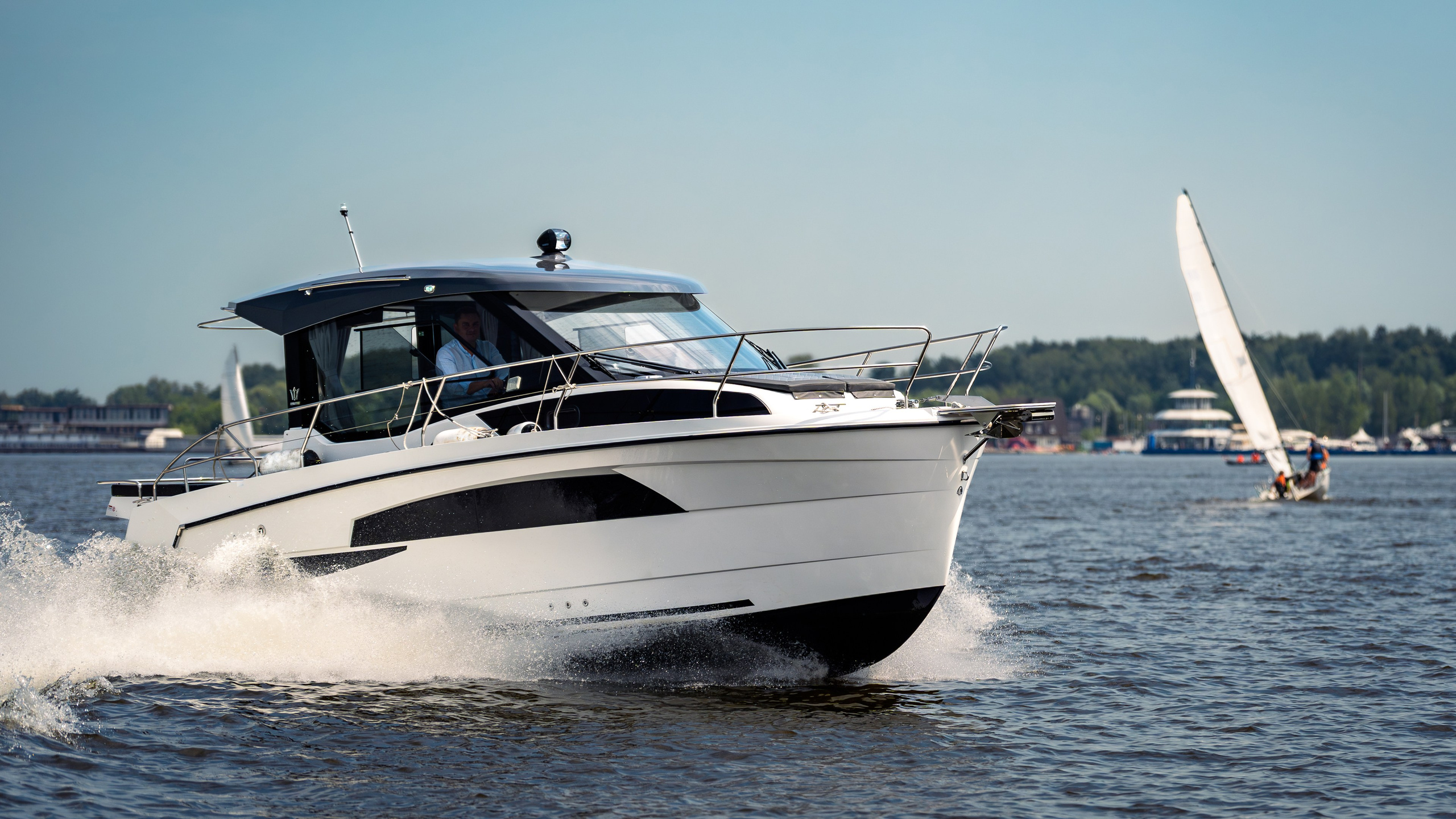 Имиджевая съёмка: Nautic 880 на ходу, белая парусная яхта на заднем плане | TrendFrame