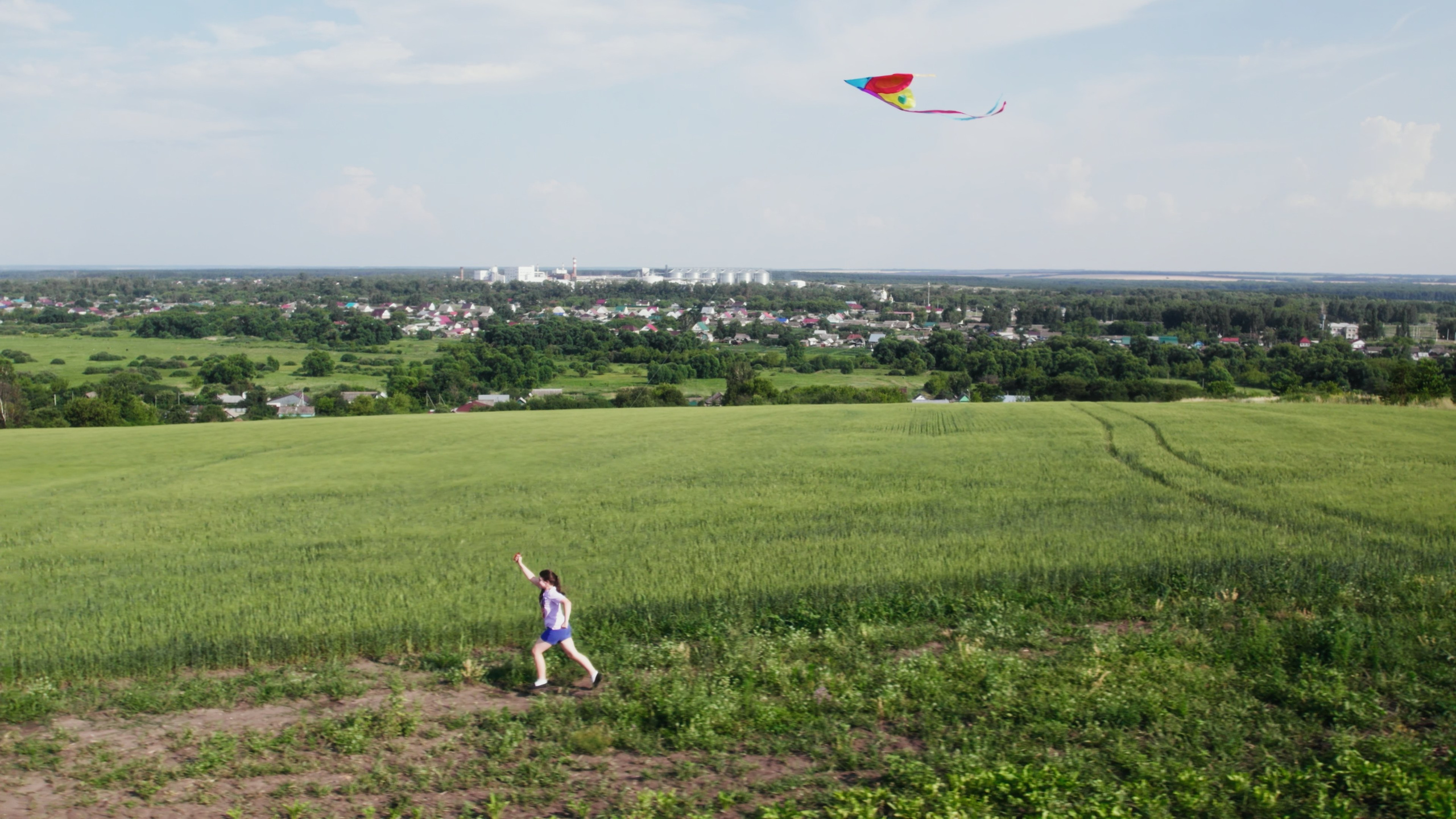 Девочка бежит по полю с воздушным змеем. Видеосъемка для социально ответственных организаций