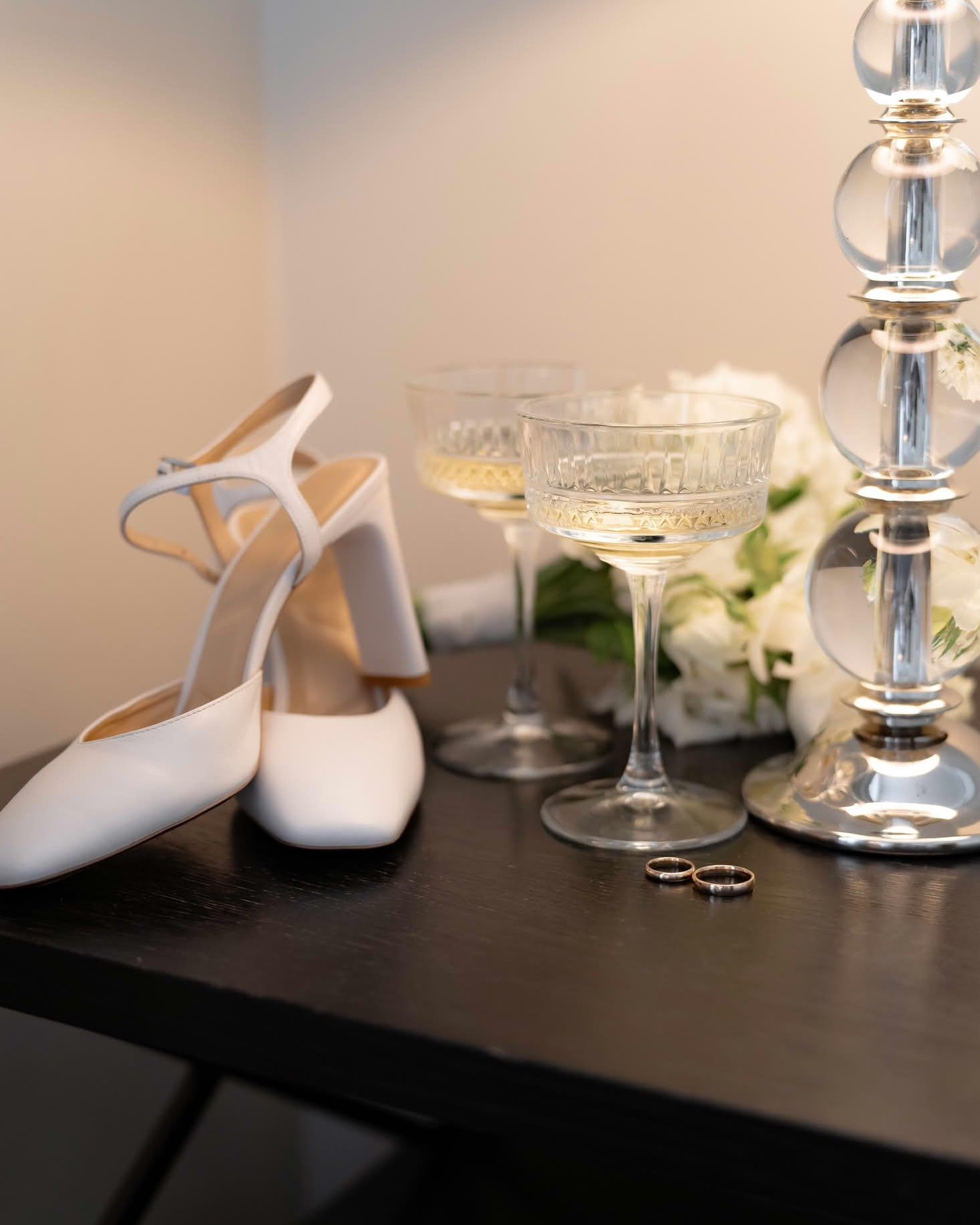 Белые свадебные туфли и бокалы с шампанским на туалетном столике