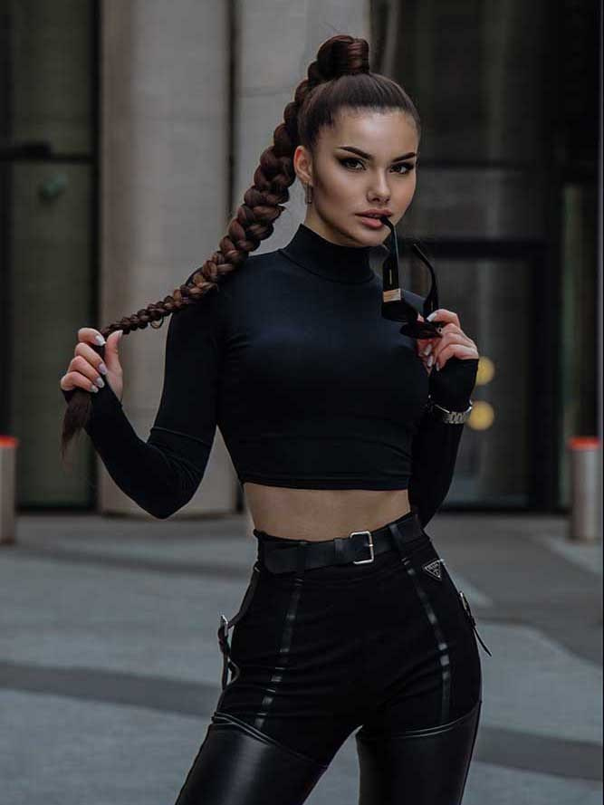 Девушка брюнетка с длинной косой в черной одежде