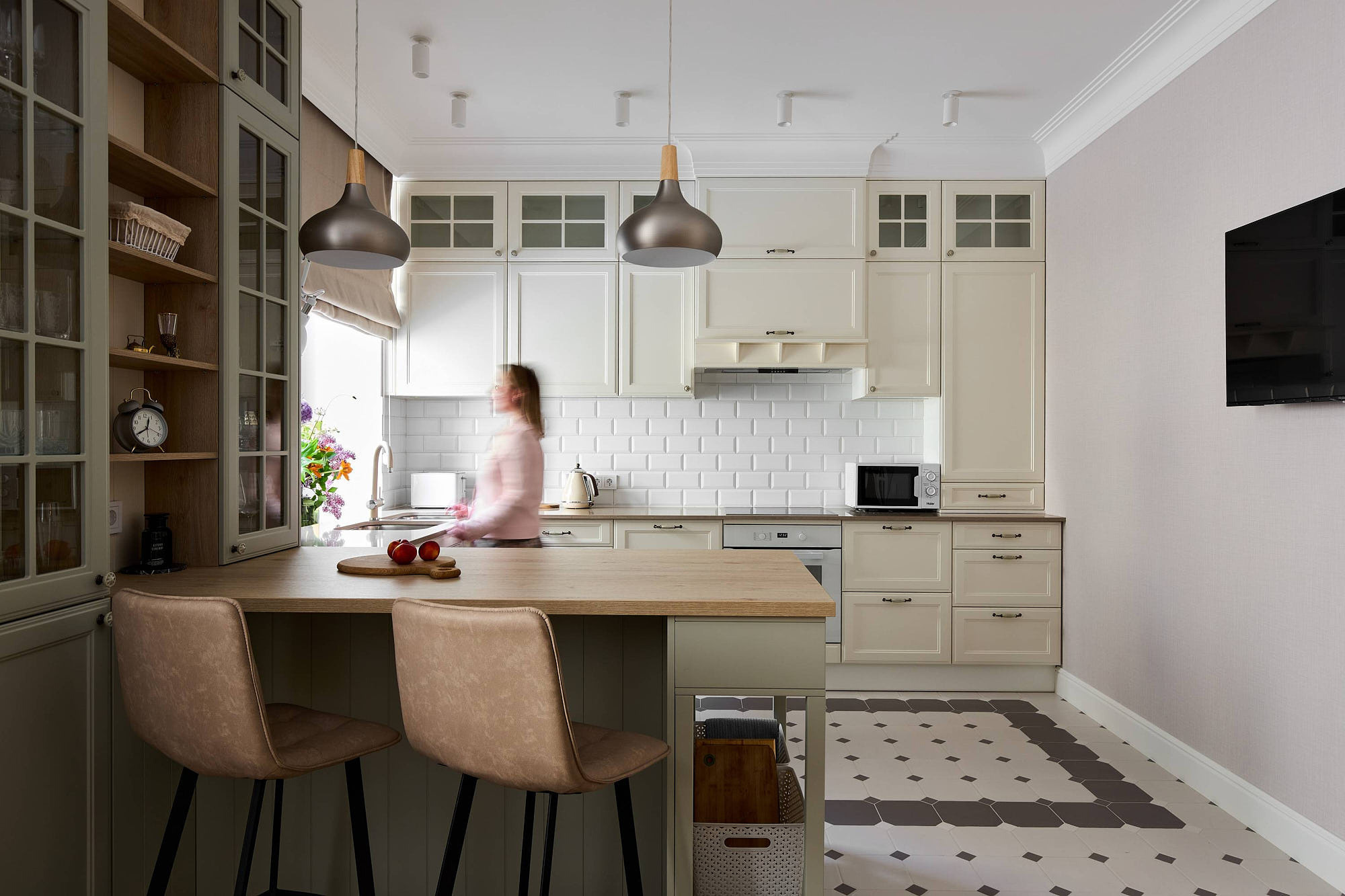 Дизайнерский ремонт на кухне с букетом цветов на окне и размытым силуэтом человека в кадре