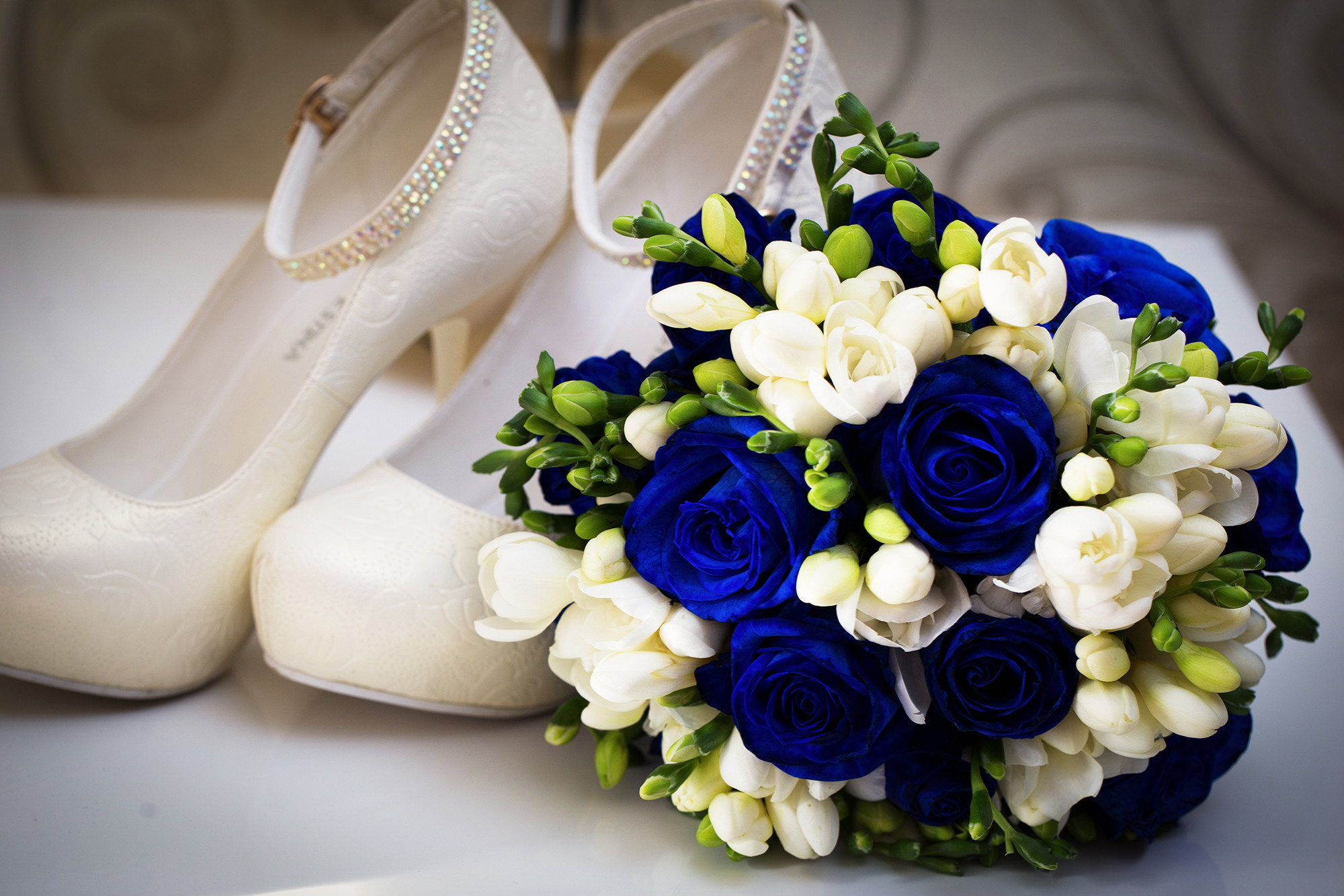 букет невесты из синих роз и белые туфли с ремешком