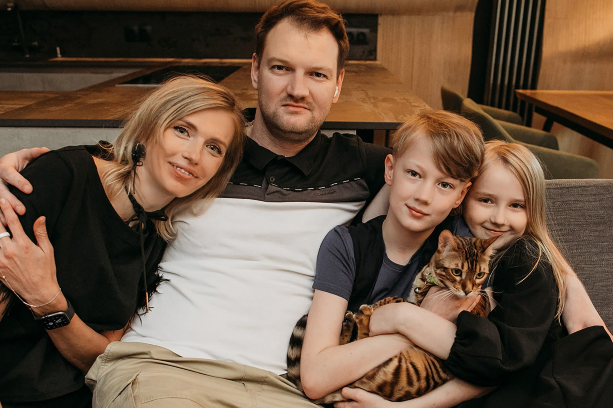 Тройняшки в джинсах на руках у мамы и папы.