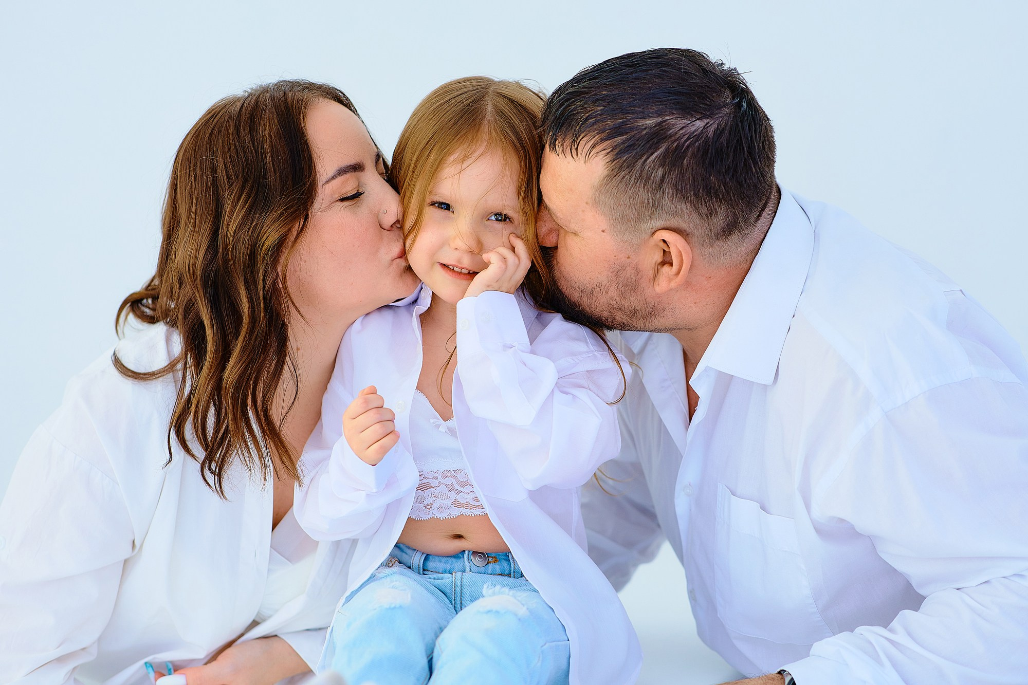 Счастливая семья, фотографирующаяся в фотостудии