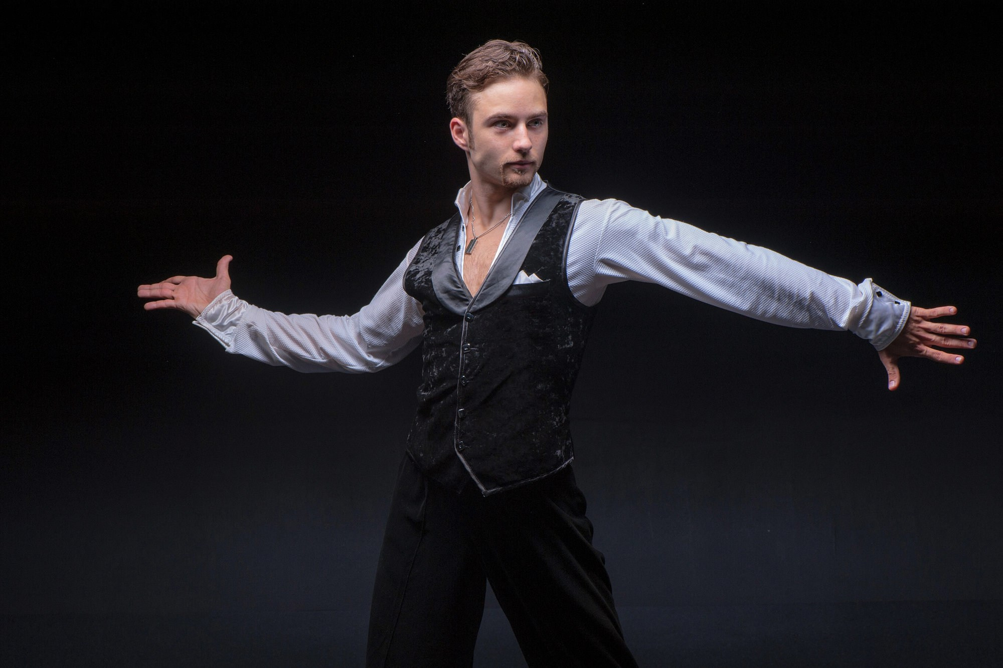 Танцор в классическом жилете выполняет выразительный жест руками, подчёркивая характер и драматичность движения. Элегантная постановочная фотосъёмка. Автор: фотограф Александр Шадрин, Москва и Истринский район.
