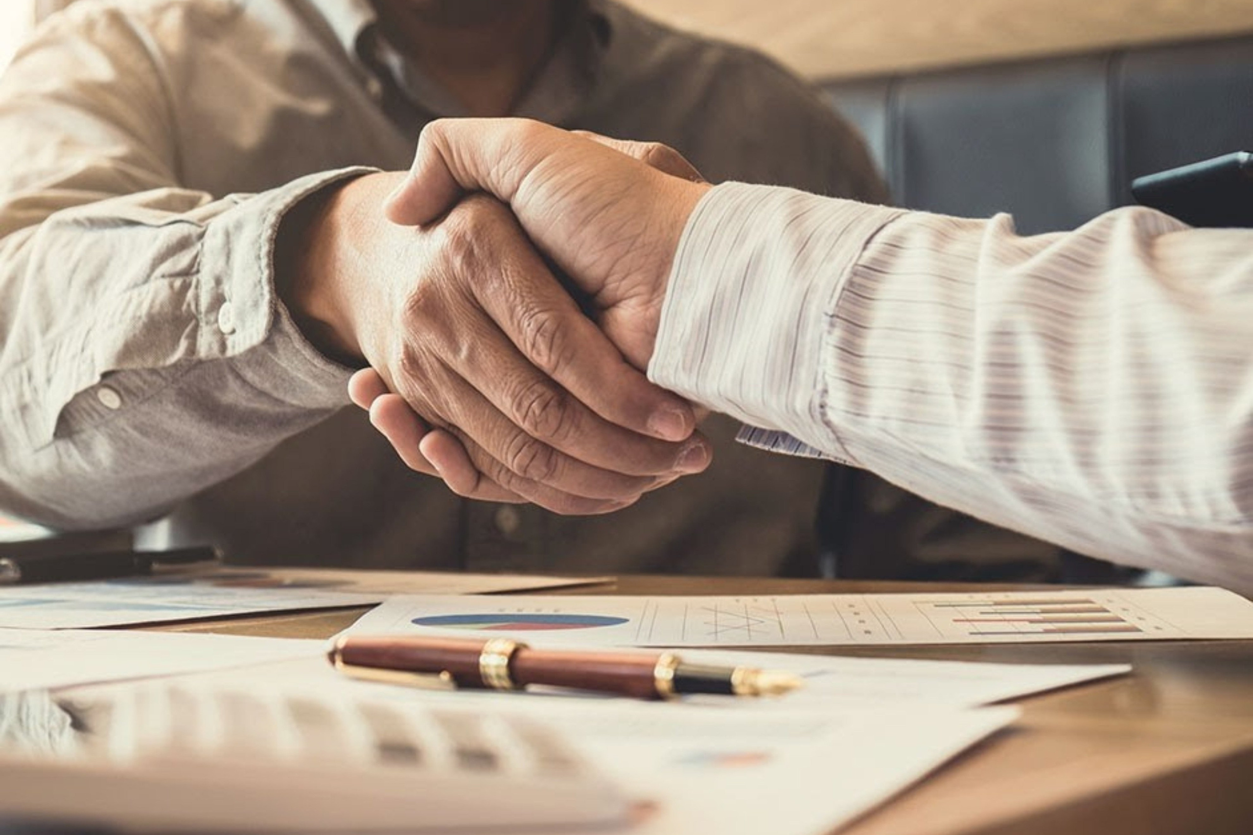 Handshake and document signing to formalize a business partnership — Supreme Travel